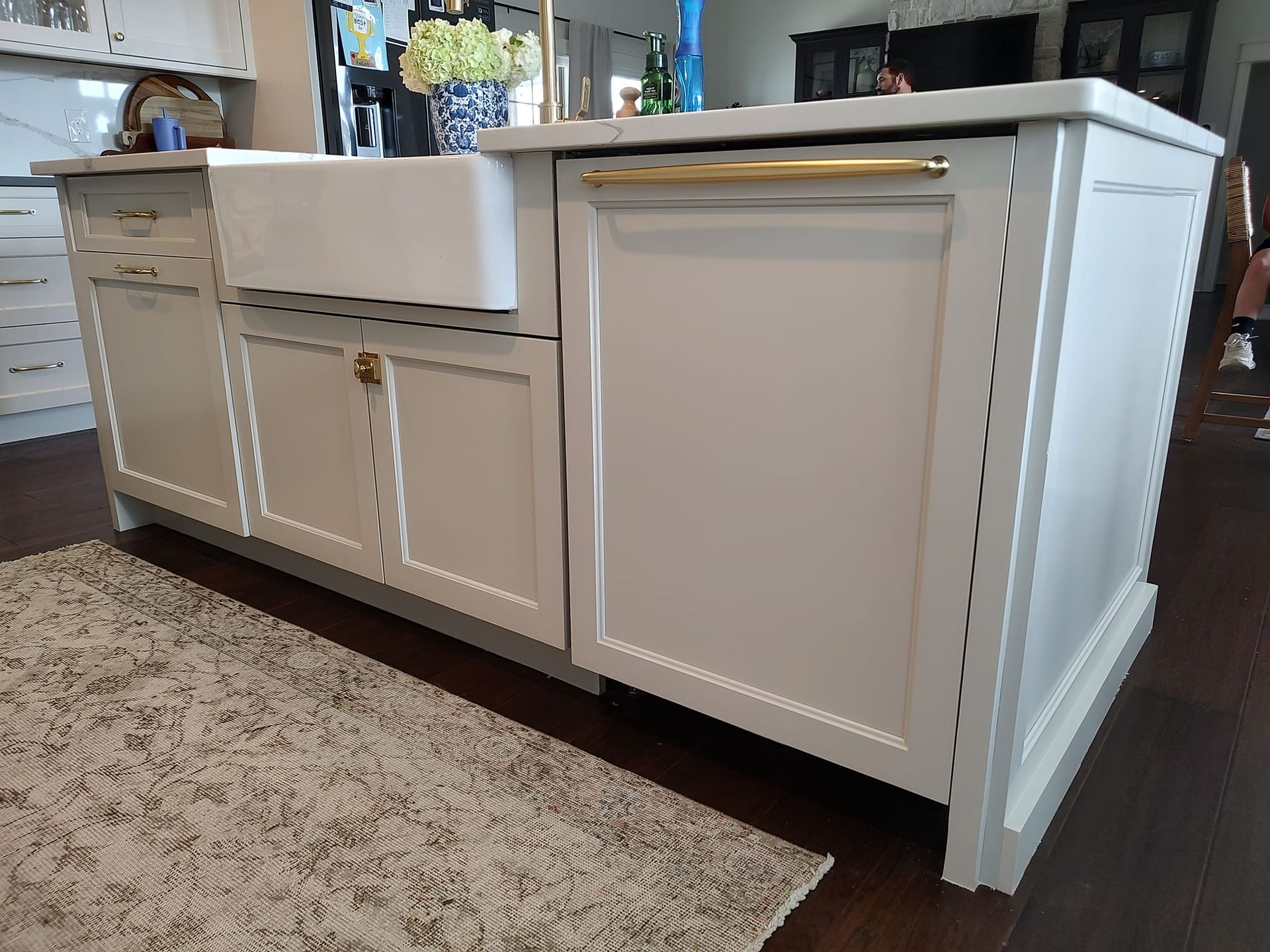 A kitchen with white cabinets and a white sink.
