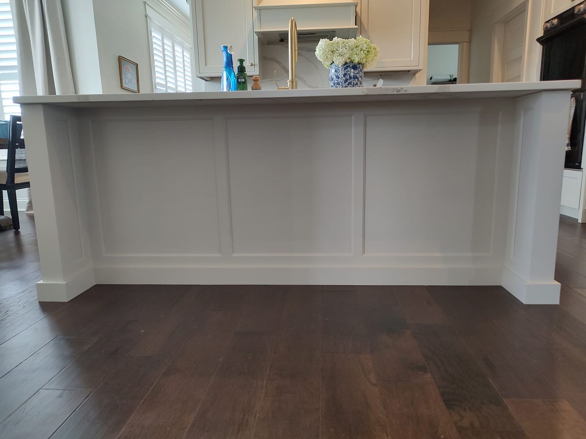 A kitchen island with a sink and a vase of flowers on it.