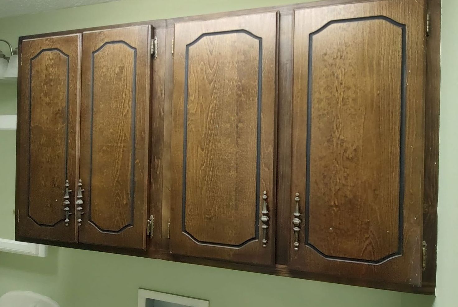 A row of wooden cabinets hanging from the ceiling in a bathroom.