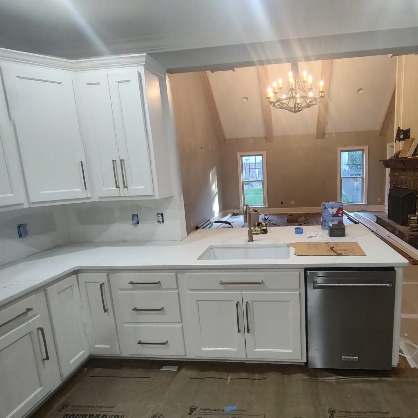 A kitchen with white cabinets and a stainless steel dishwasher