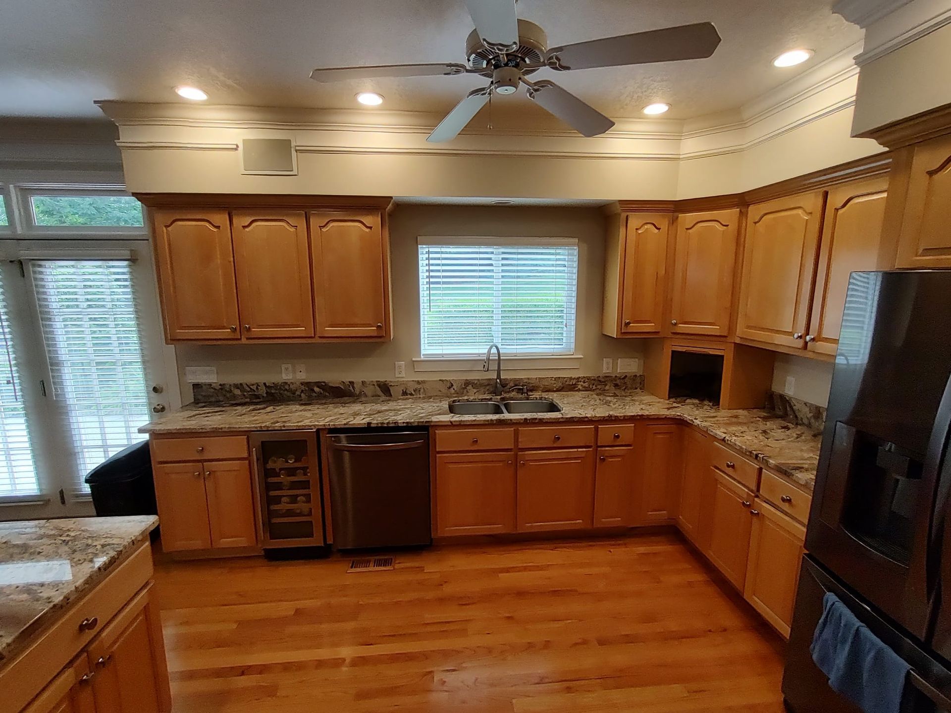 A kitchen with wooden cabinets and a ceiling fan
