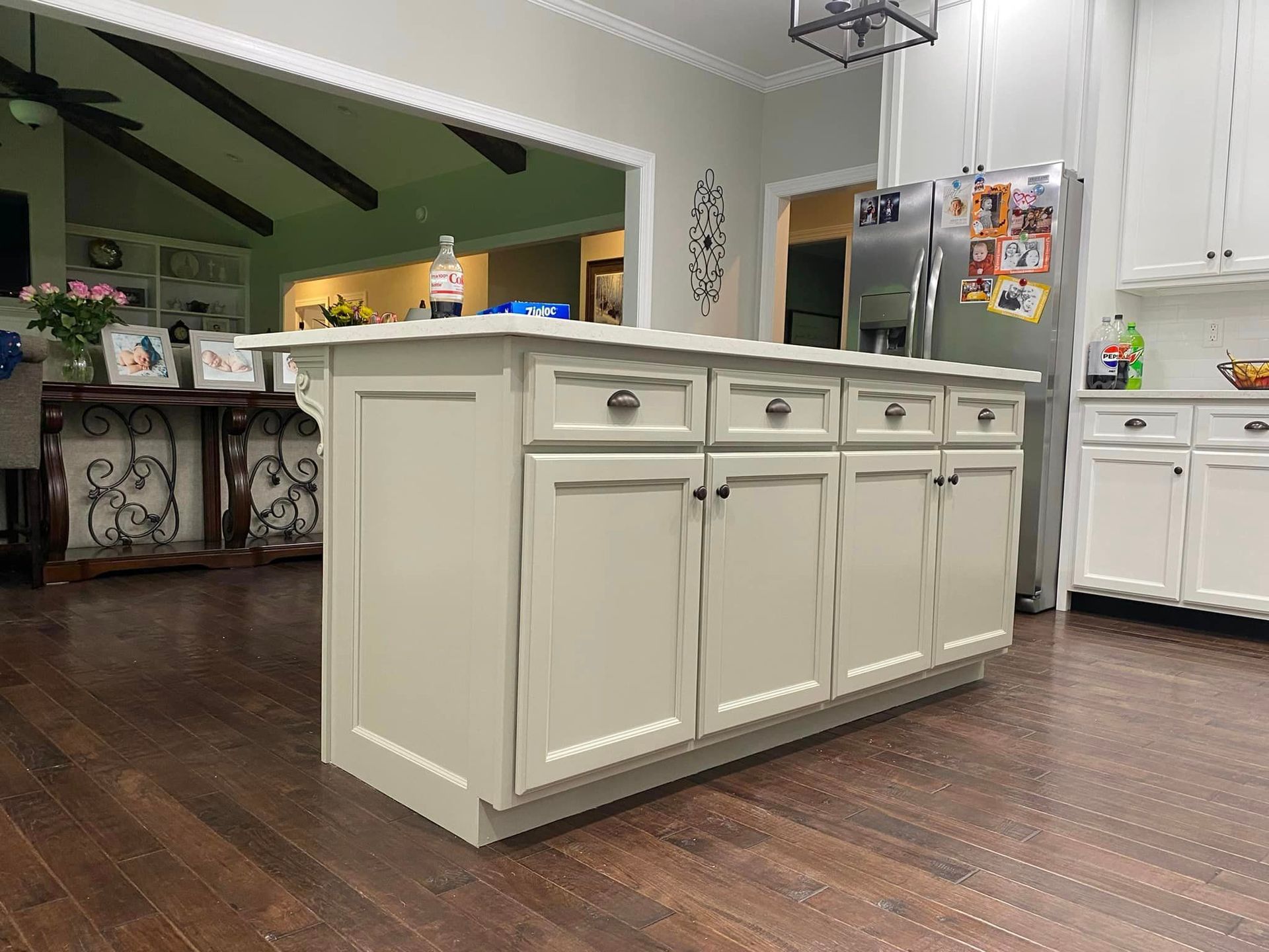 A kitchen with white cabinets and a large island in the middle.