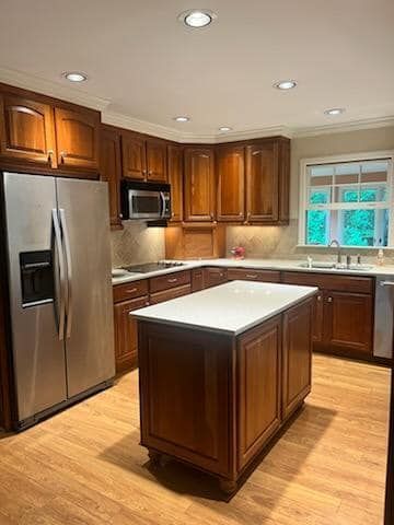 A kitchen with wooden cabinets , stainless steel appliances , and a large island.