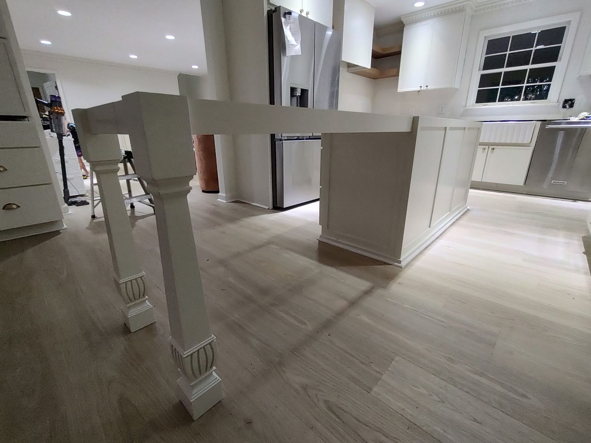 A kitchen with a white table and stainless steel appliances.