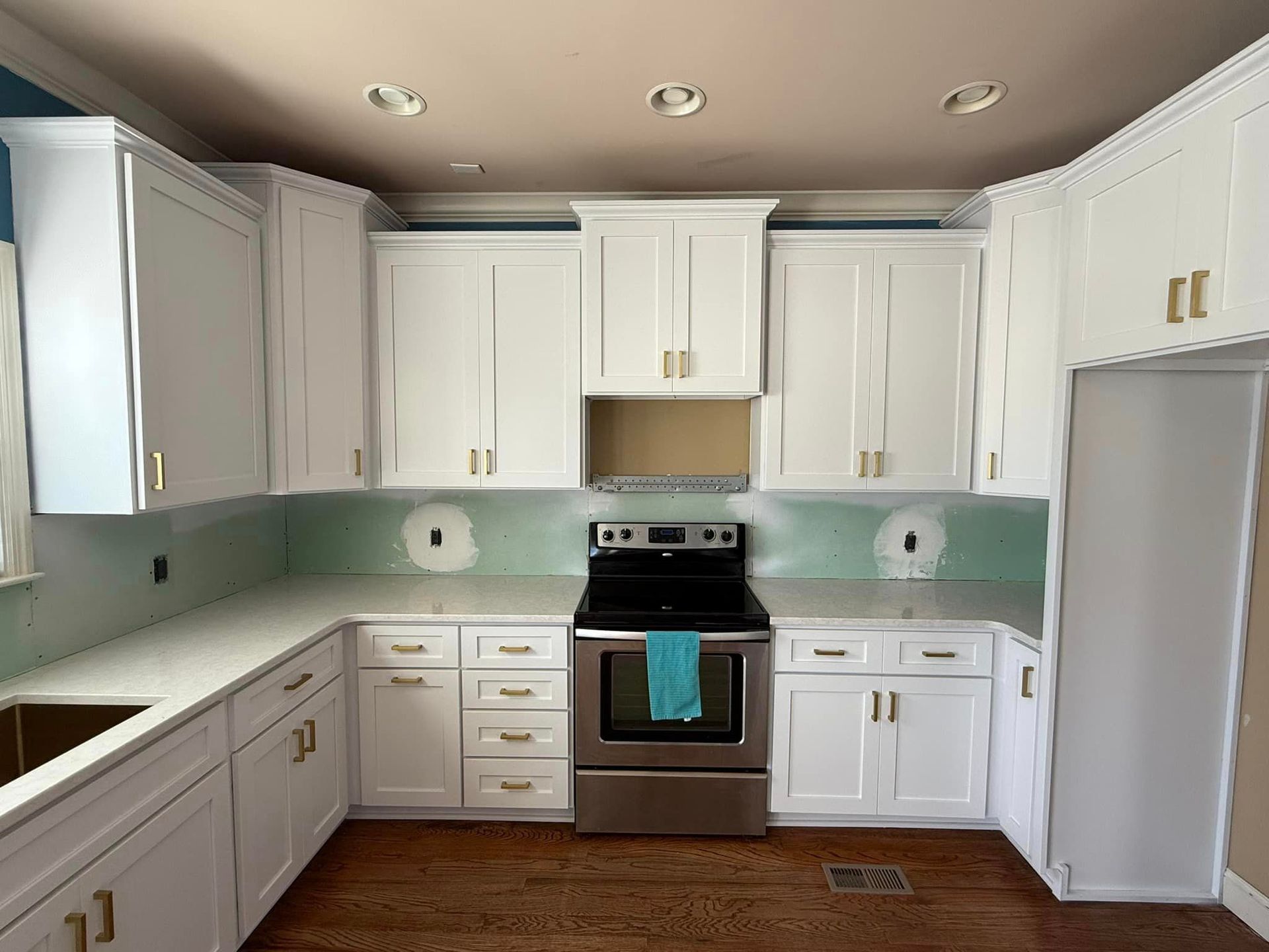 A kitchen with white cabinets and stainless steel appliances