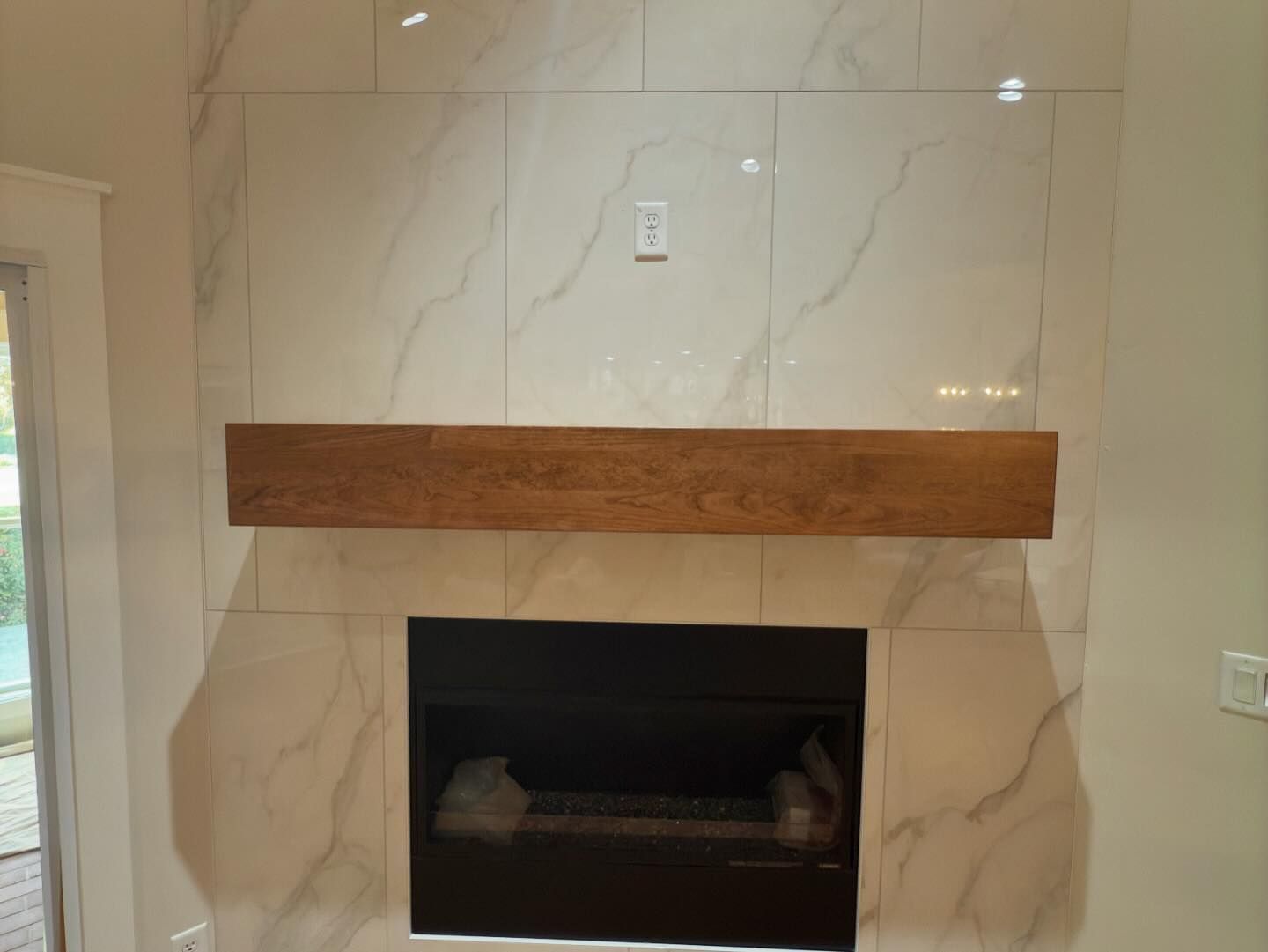 A fireplace with a wooden mantle in a living room.