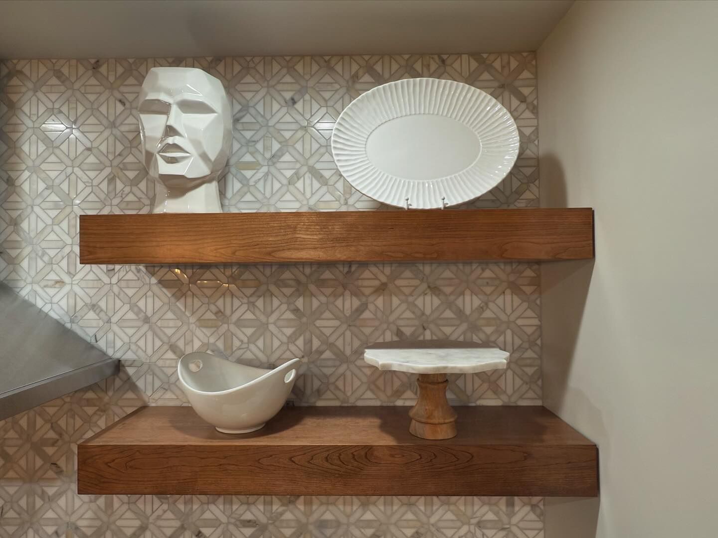 A wooden shelf with plates and a statue on it.