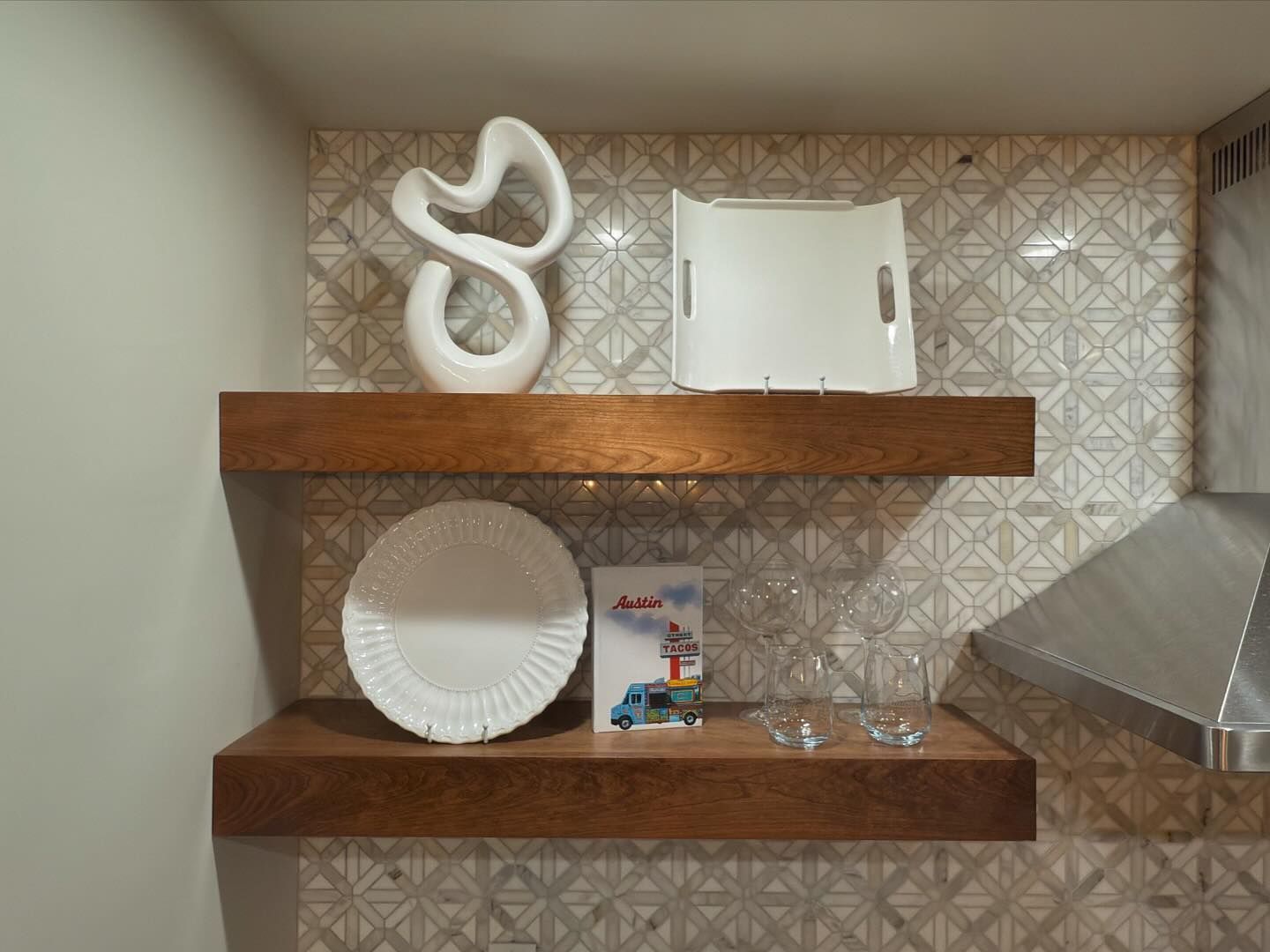 A wooden shelf with plates and a vase on it