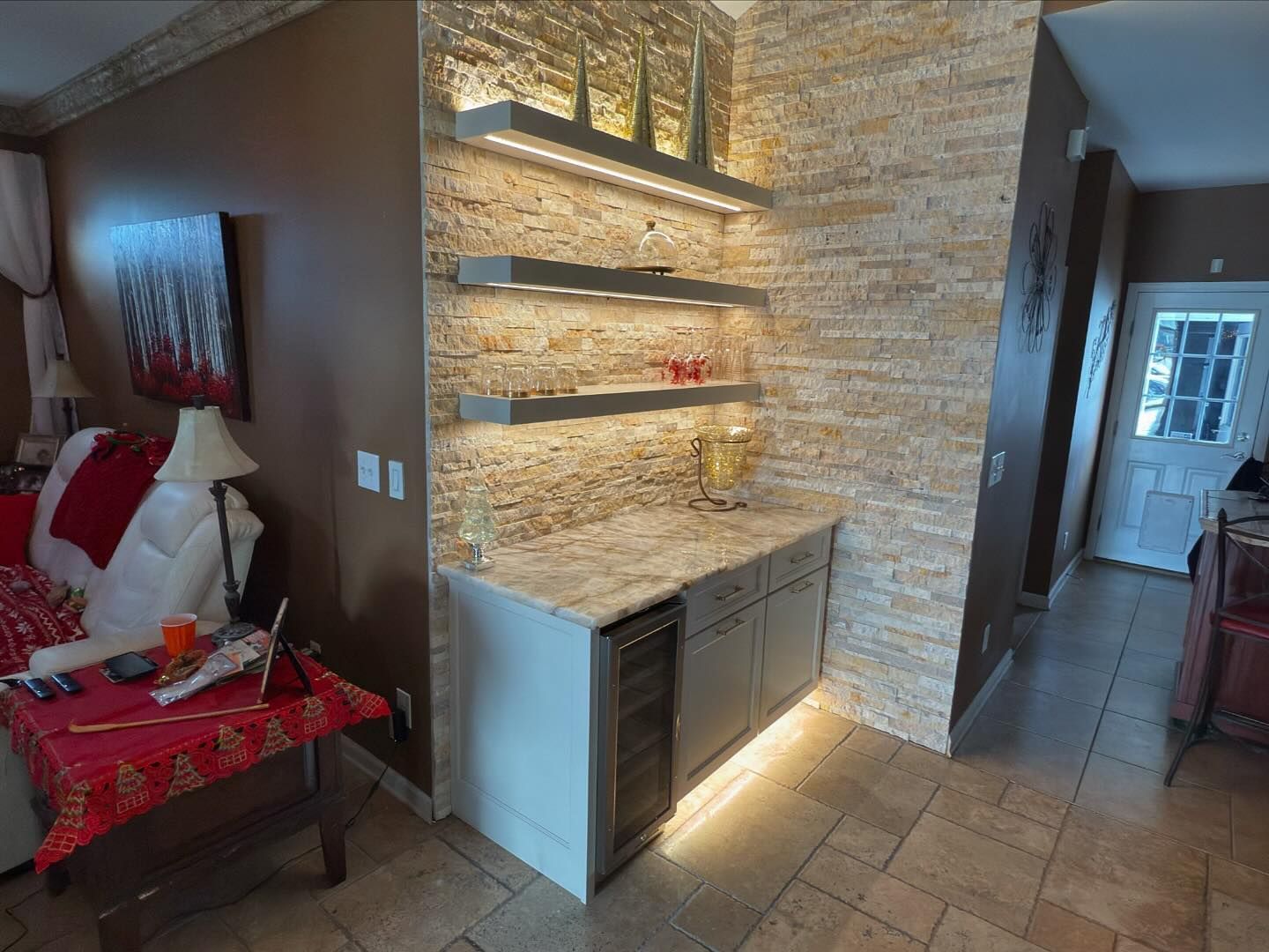 A kitchen with a bar and a refrigerator in it.