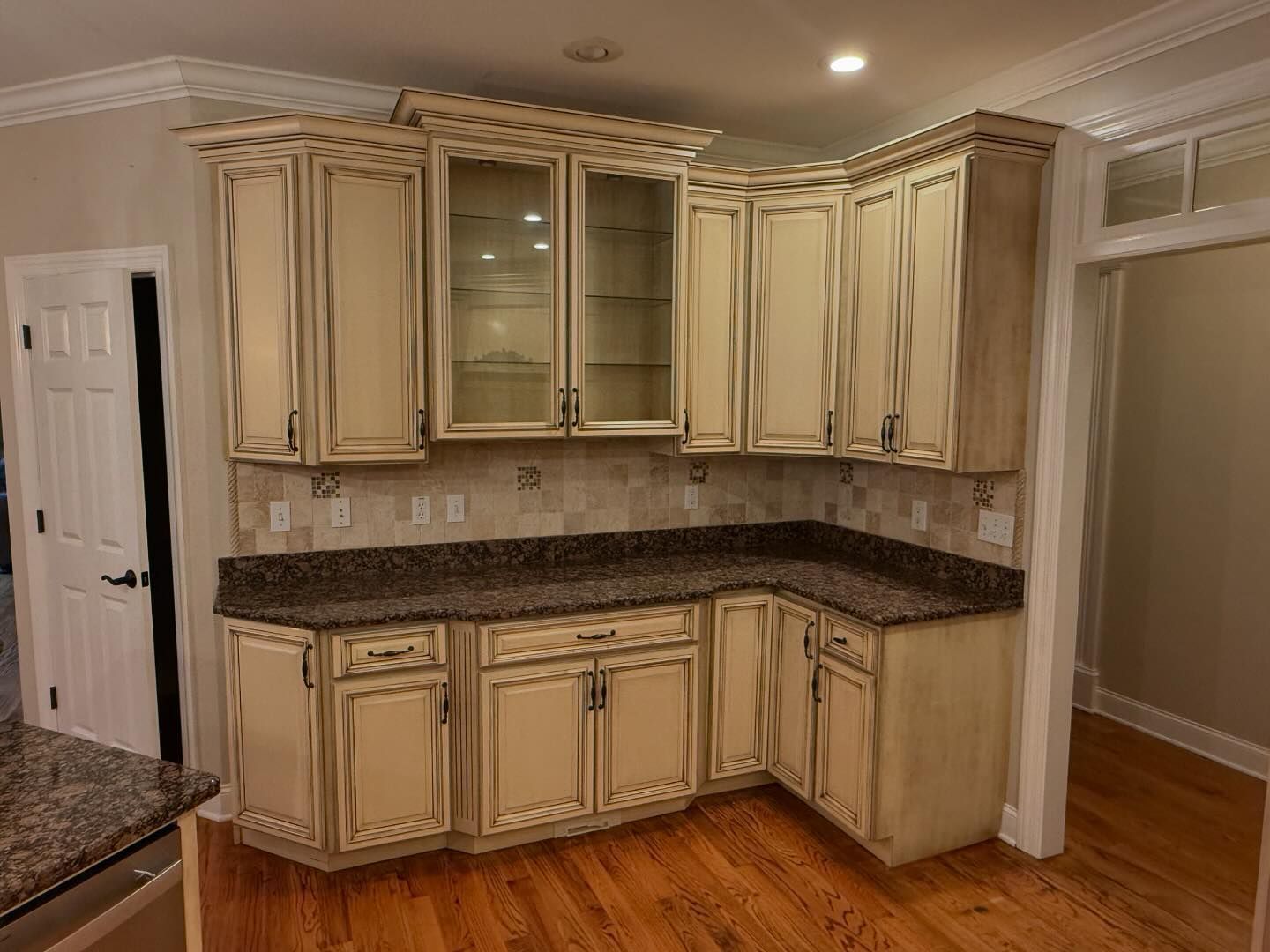 A kitchen with white cabinets and granite counter tops.