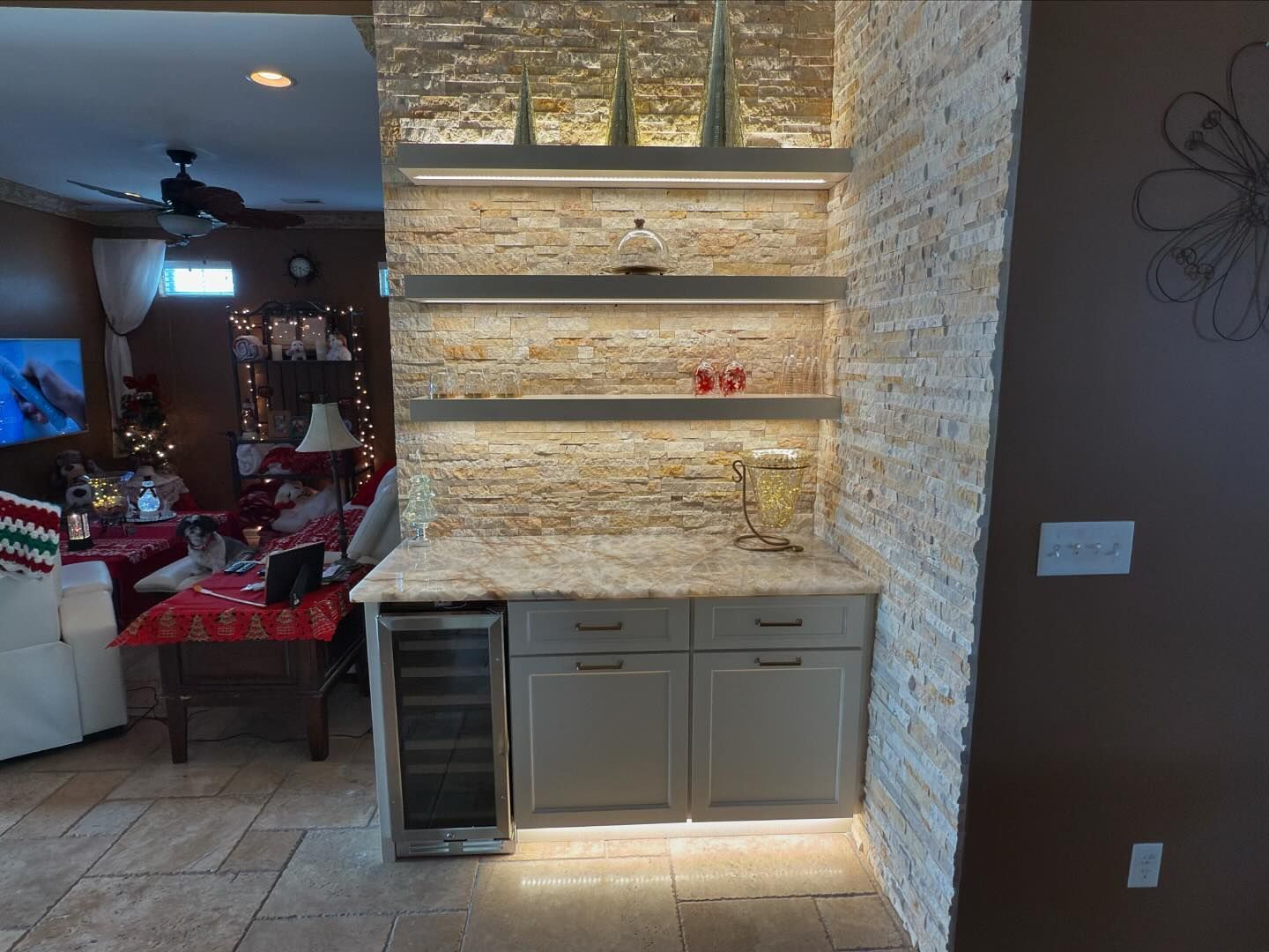 A kitchen with a wine cooler and shelves.