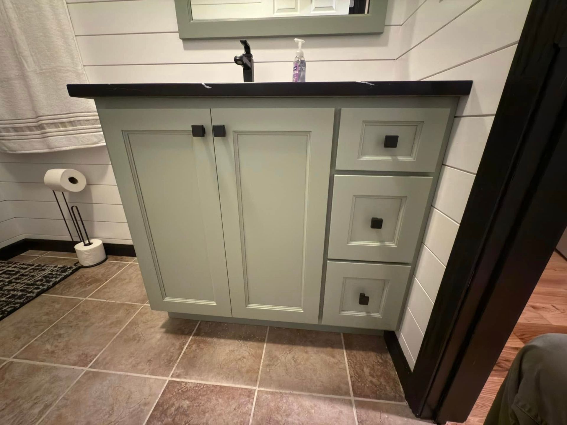 A bathroom vanity with a sink , mirror and drawers.