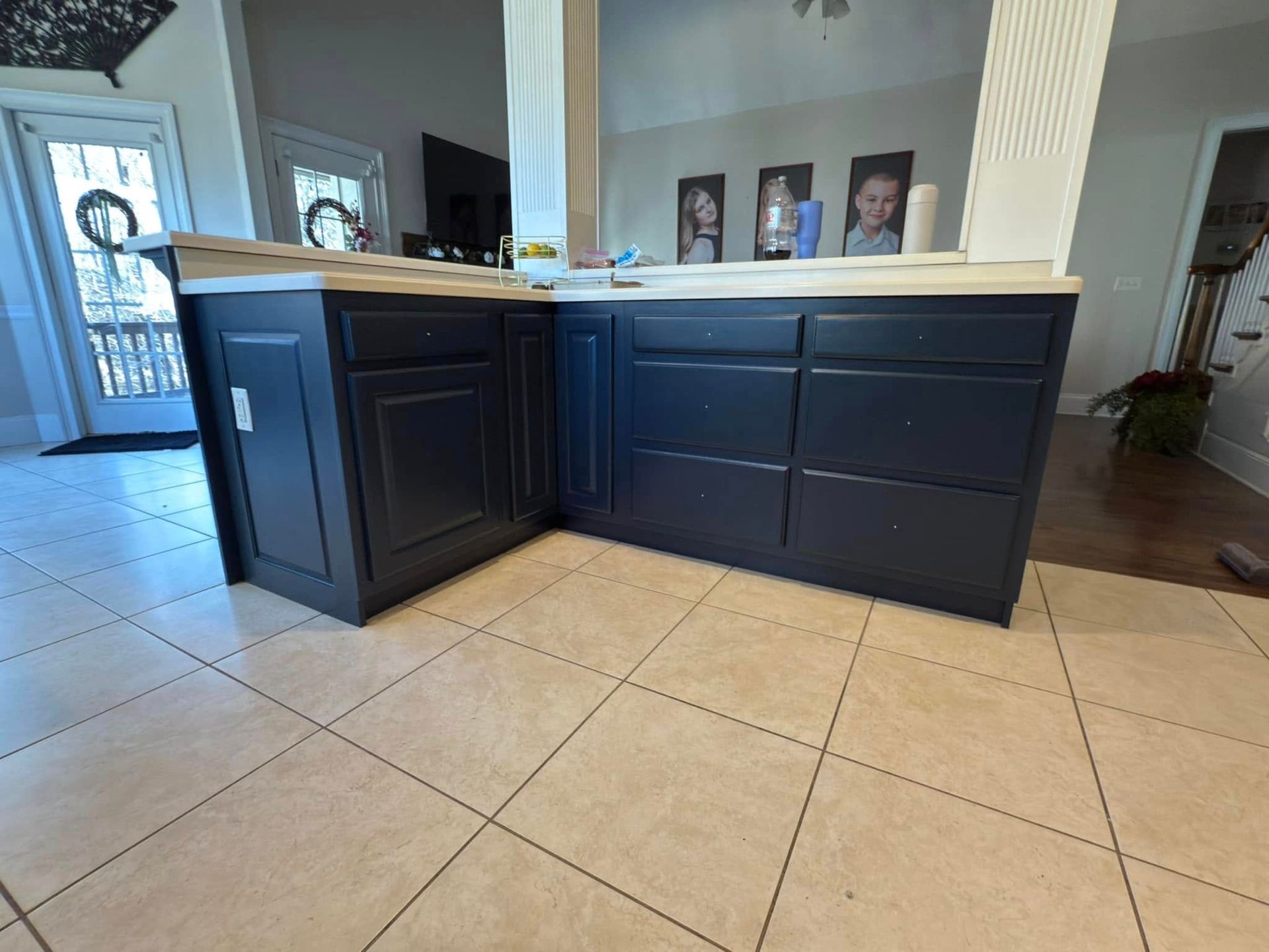 A kitchen with blue cabinets and a tiled floor.