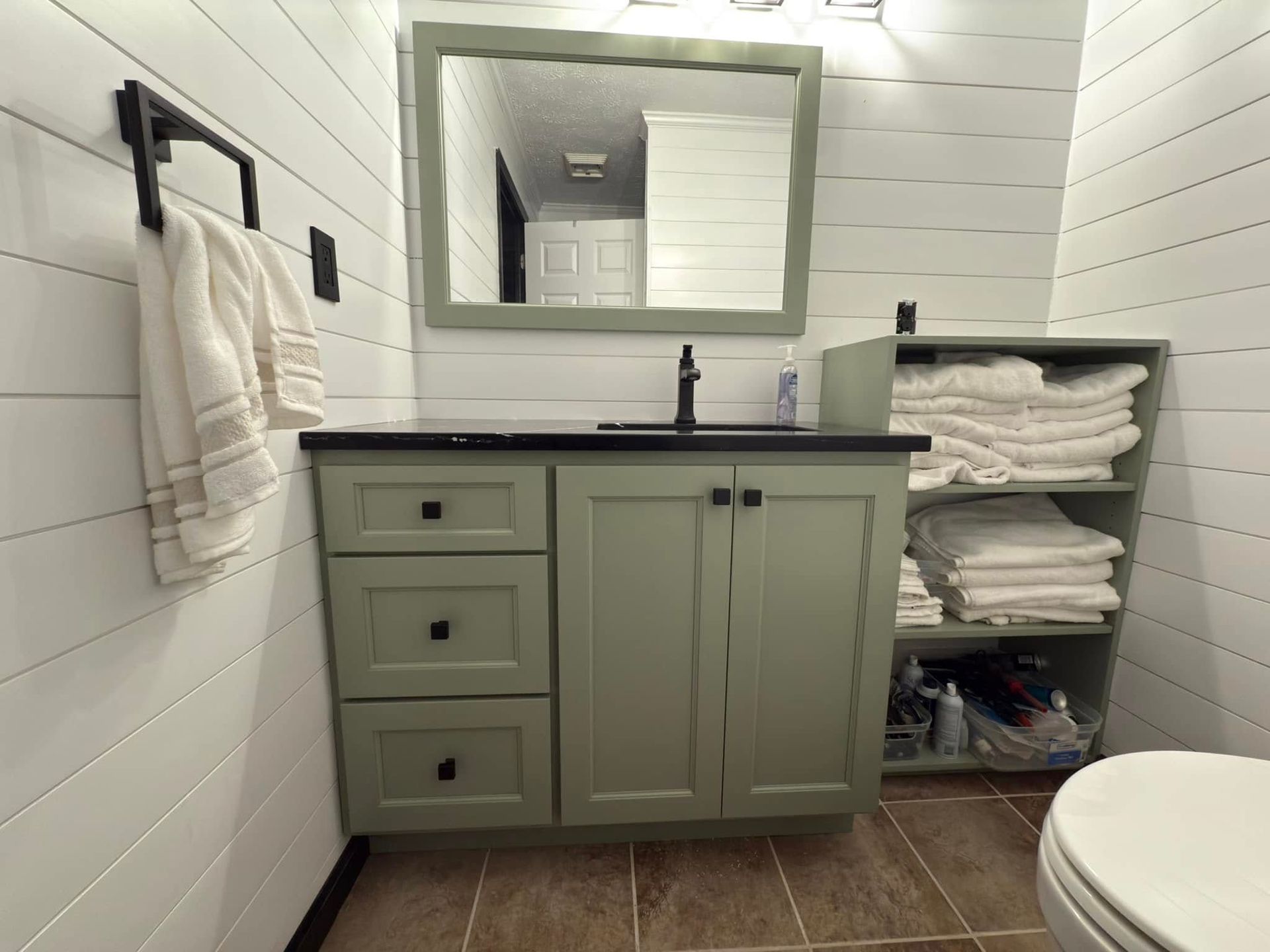 A bathroom with a sink , mirror , and toilet.
