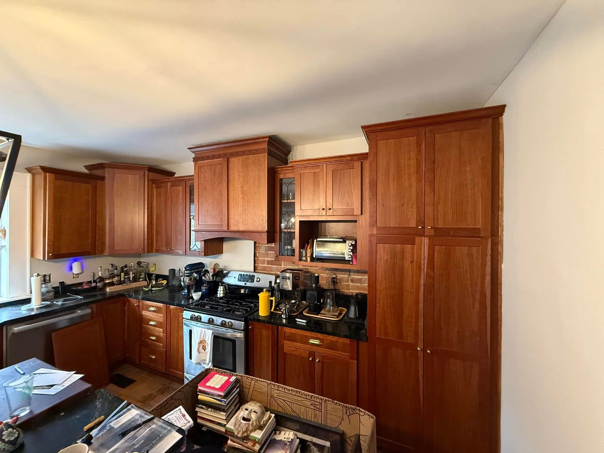 A kitchen with wooden cabinets and black counter tops