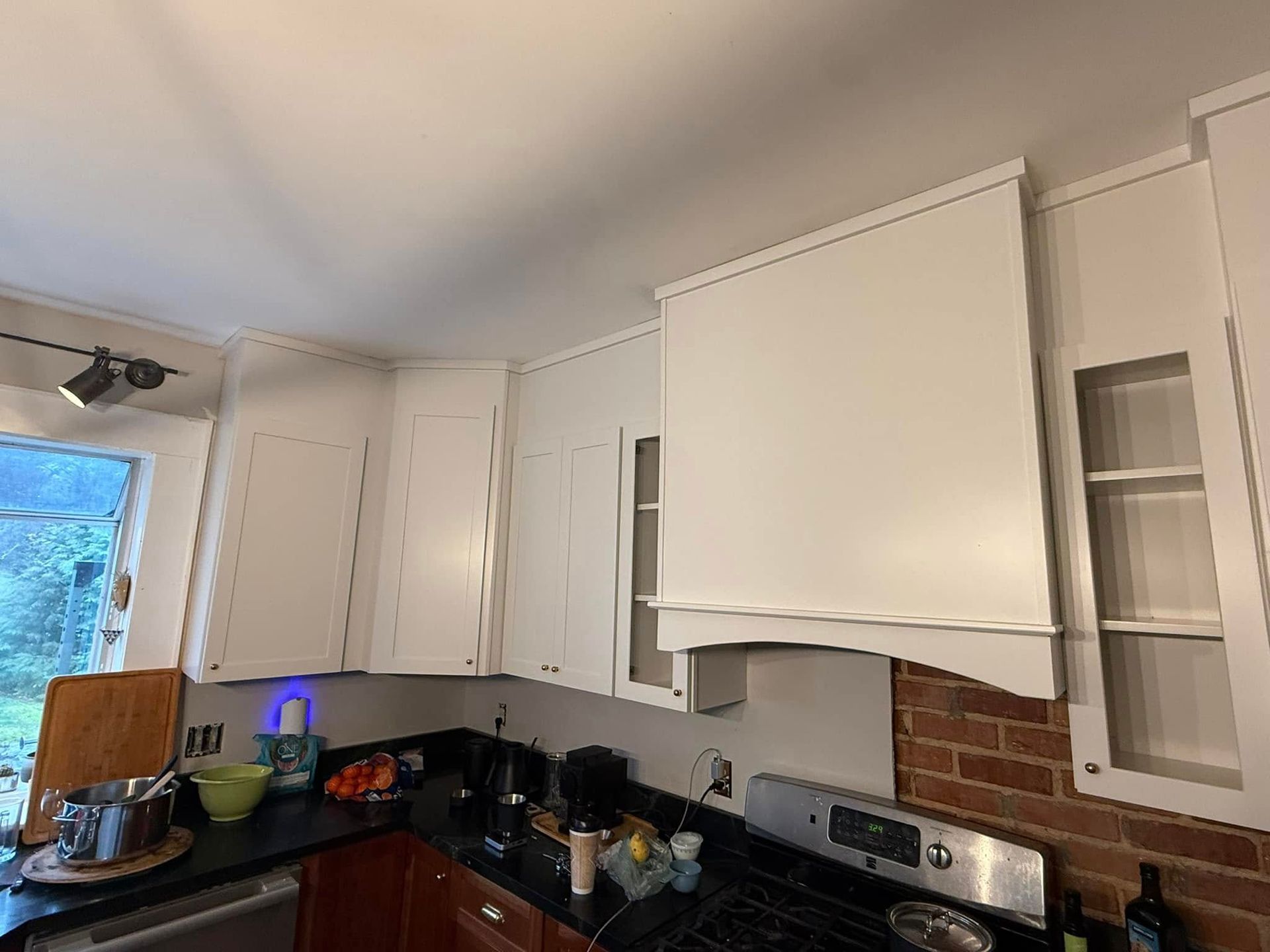 A kitchen with white cabinets and a stove top oven.
