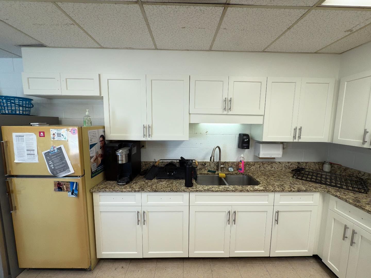 A kitchen with white cabinets and a yellow refrigerator