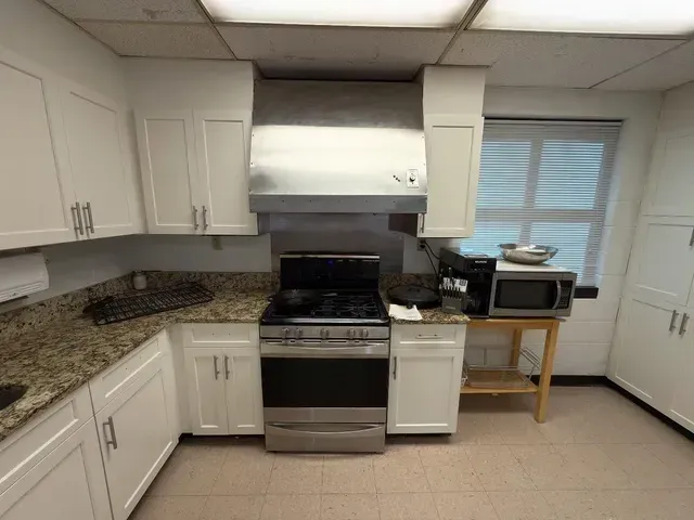 A kitchen with stainless steel appliances and white cabinets