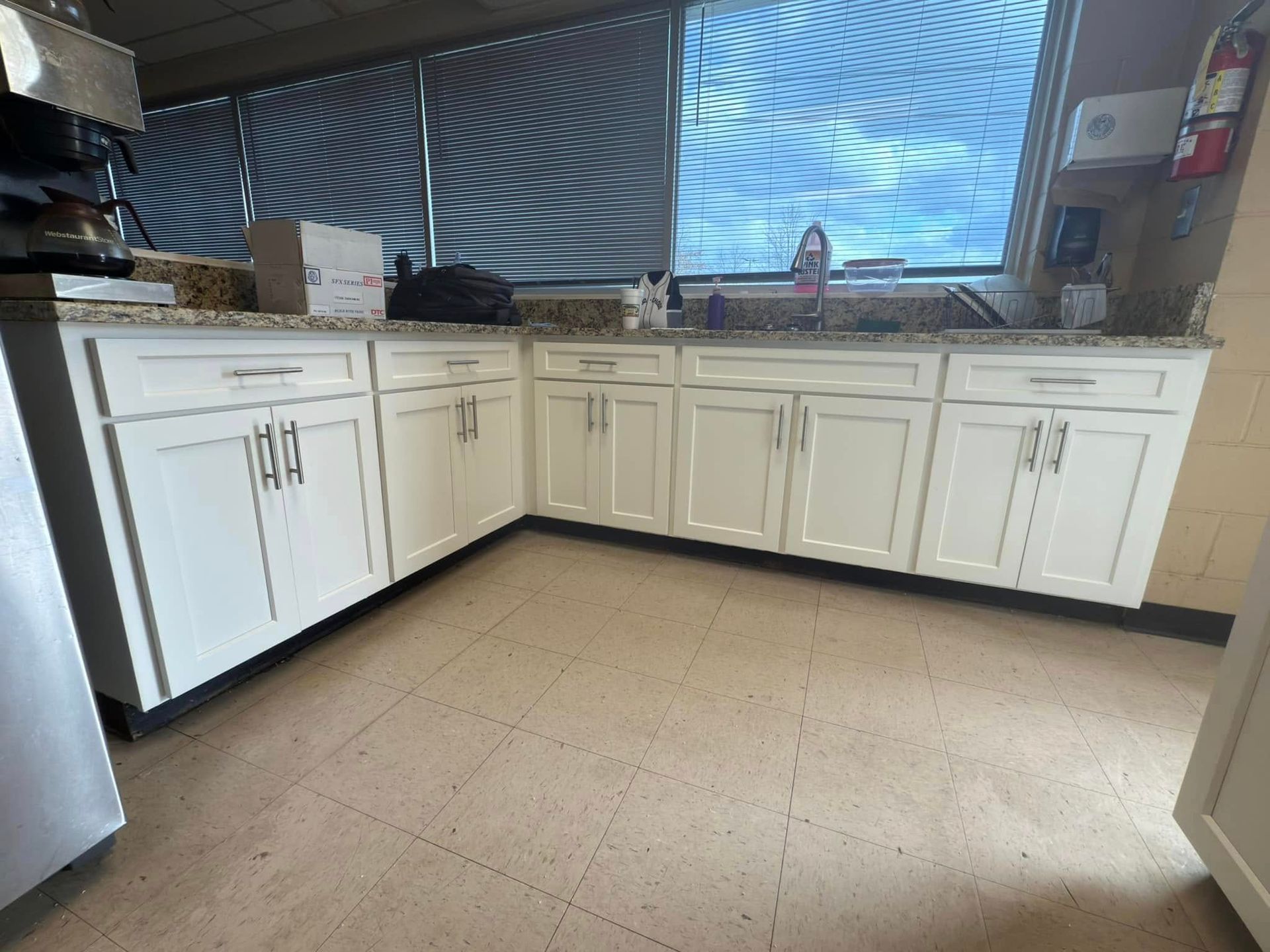 A kitchen with white cabinets and granite counter tops