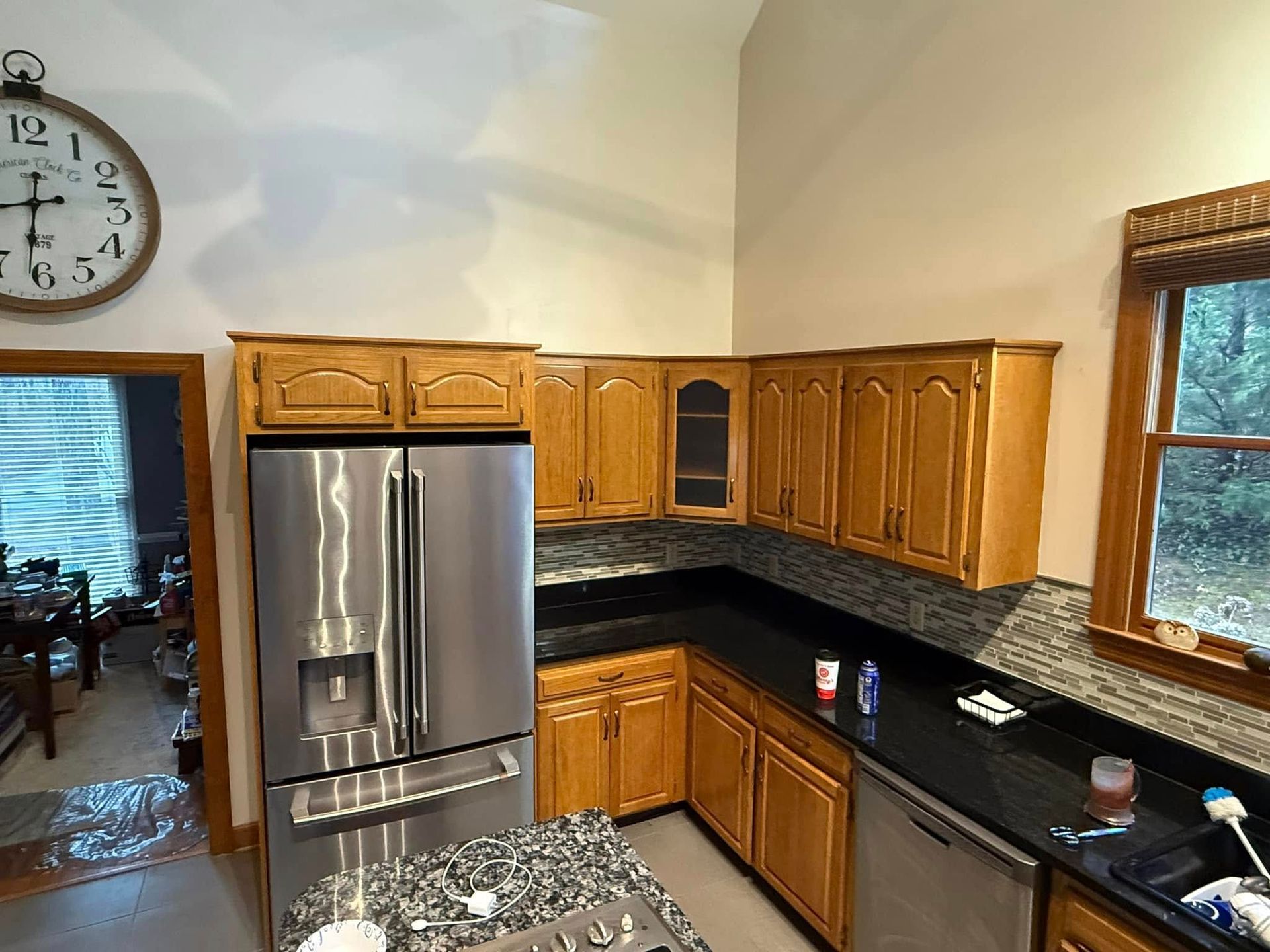 A kitchen with stainless steel appliances and a clock on the wall