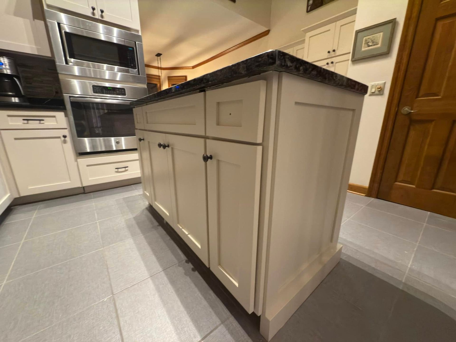 A kitchen with white cabinets and stainless steel appliances