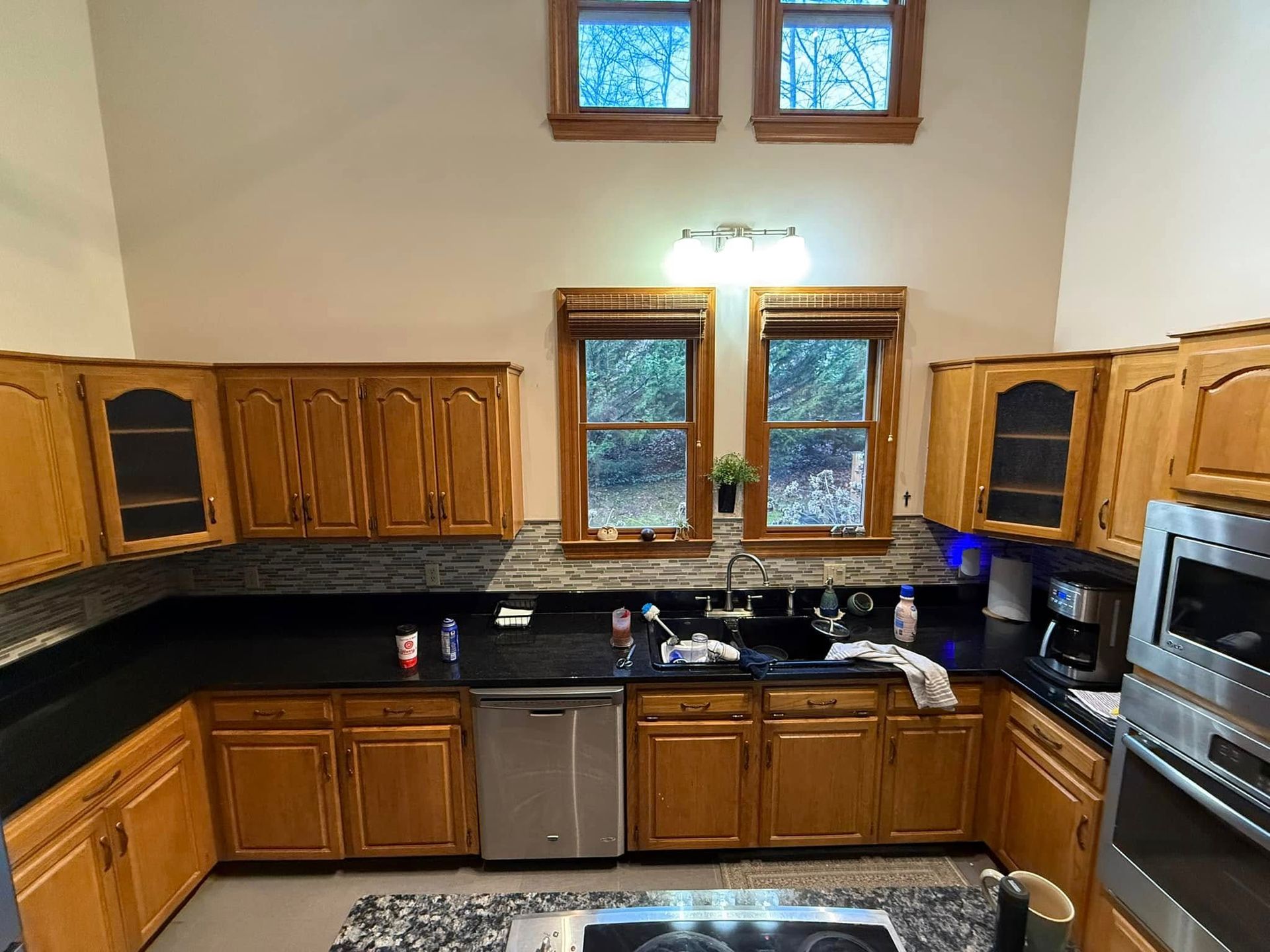 A kitchen with wooden cabinets and black counter tops