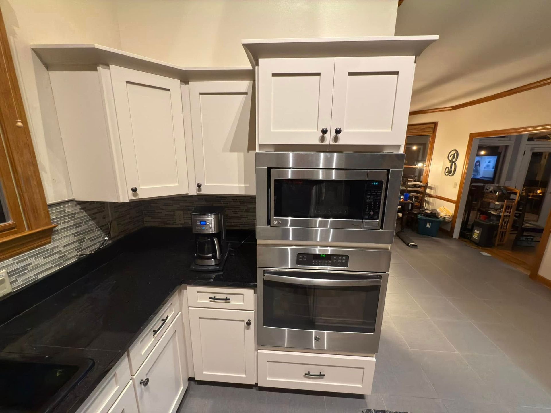 A kitchen with white cabinets and stainless steel appliances.