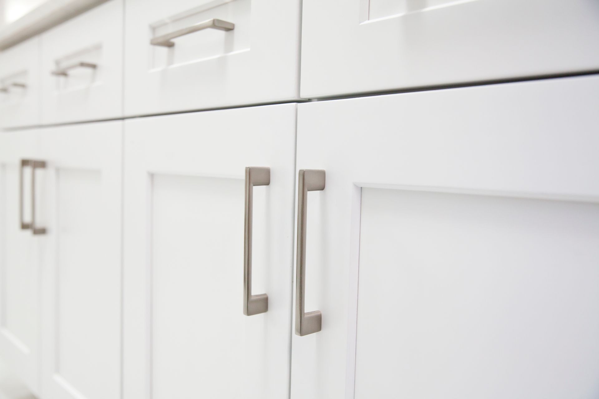 A close up of a kitchen cabinet with stainless steel handles.