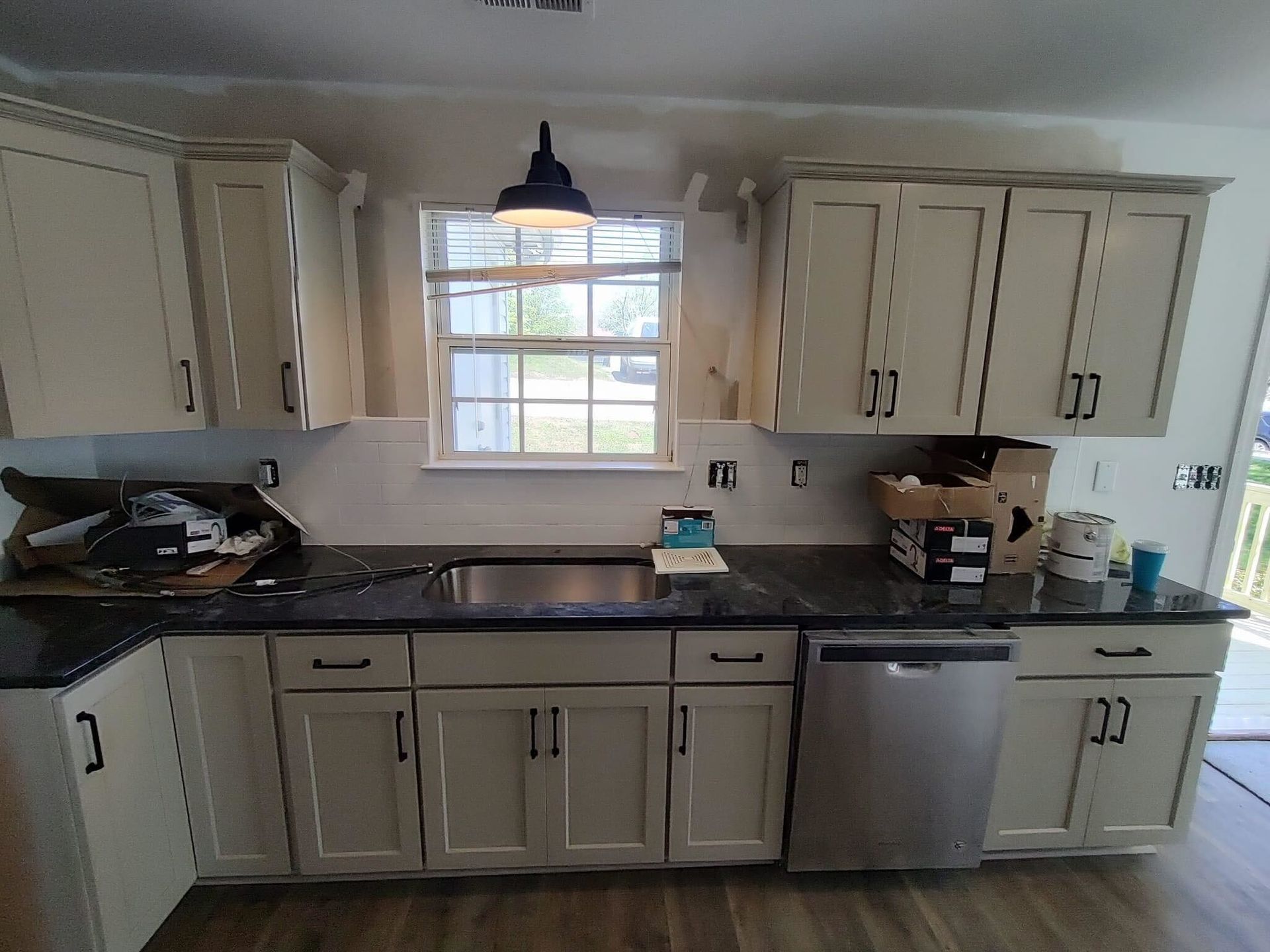 A kitchen with white cabinets and a stainless steel dishwasher