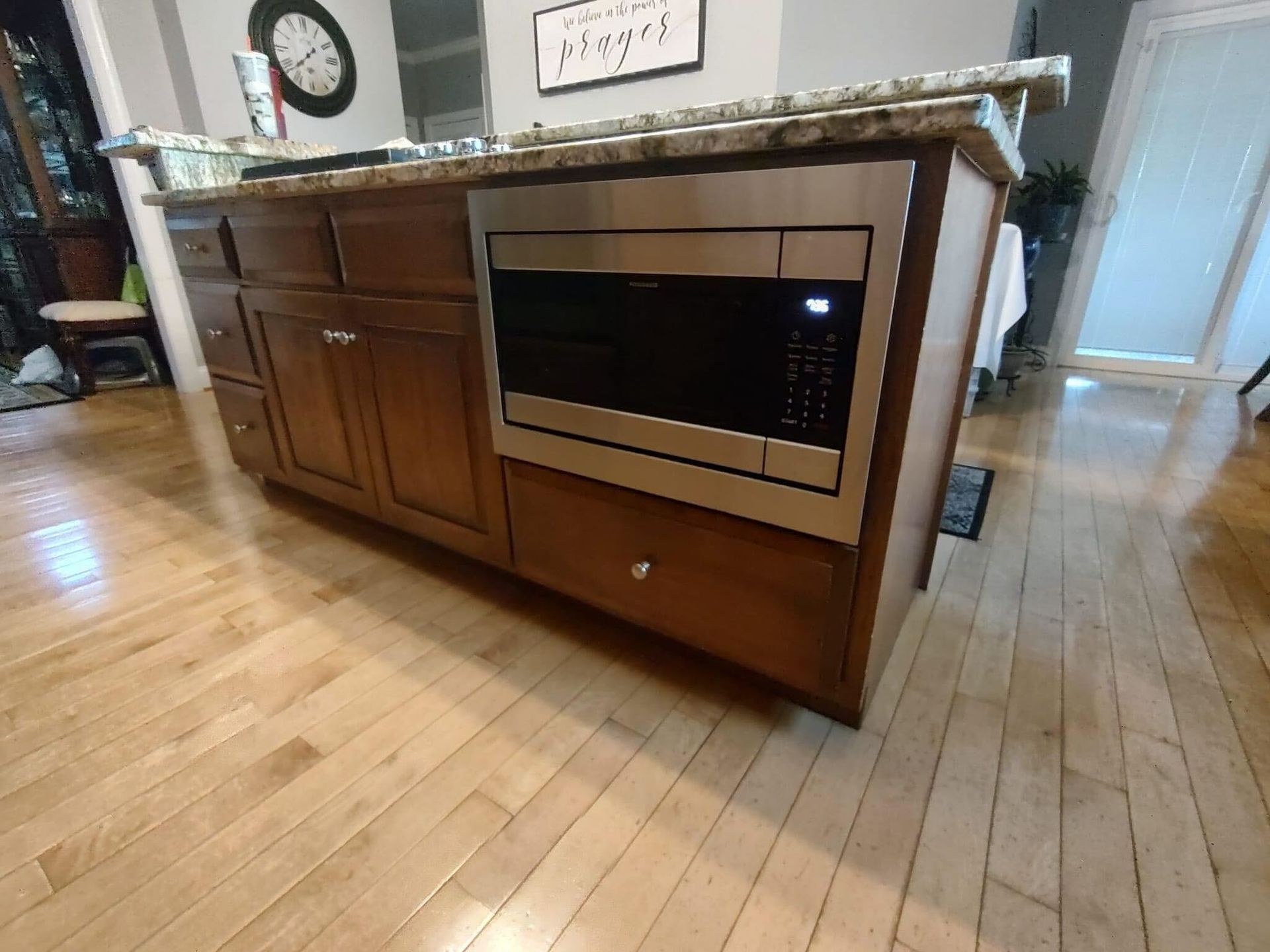 A kitchen island with a microwave built into it.