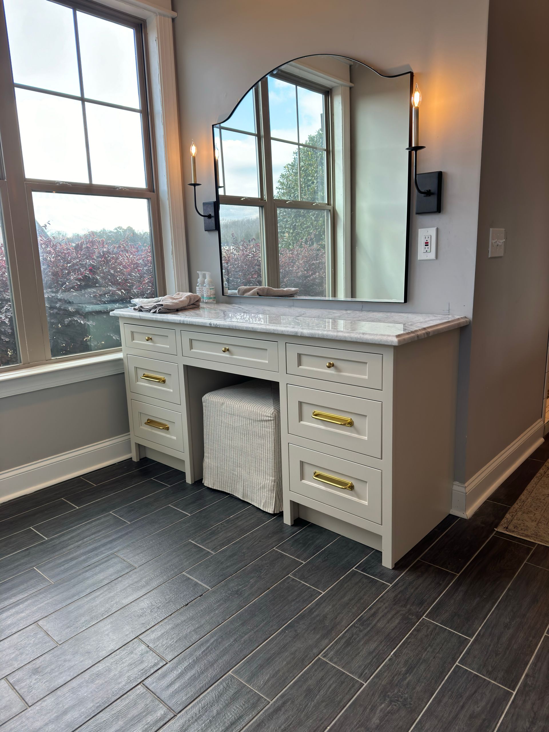 A bathroom vanity with a large mirror and a sink.
