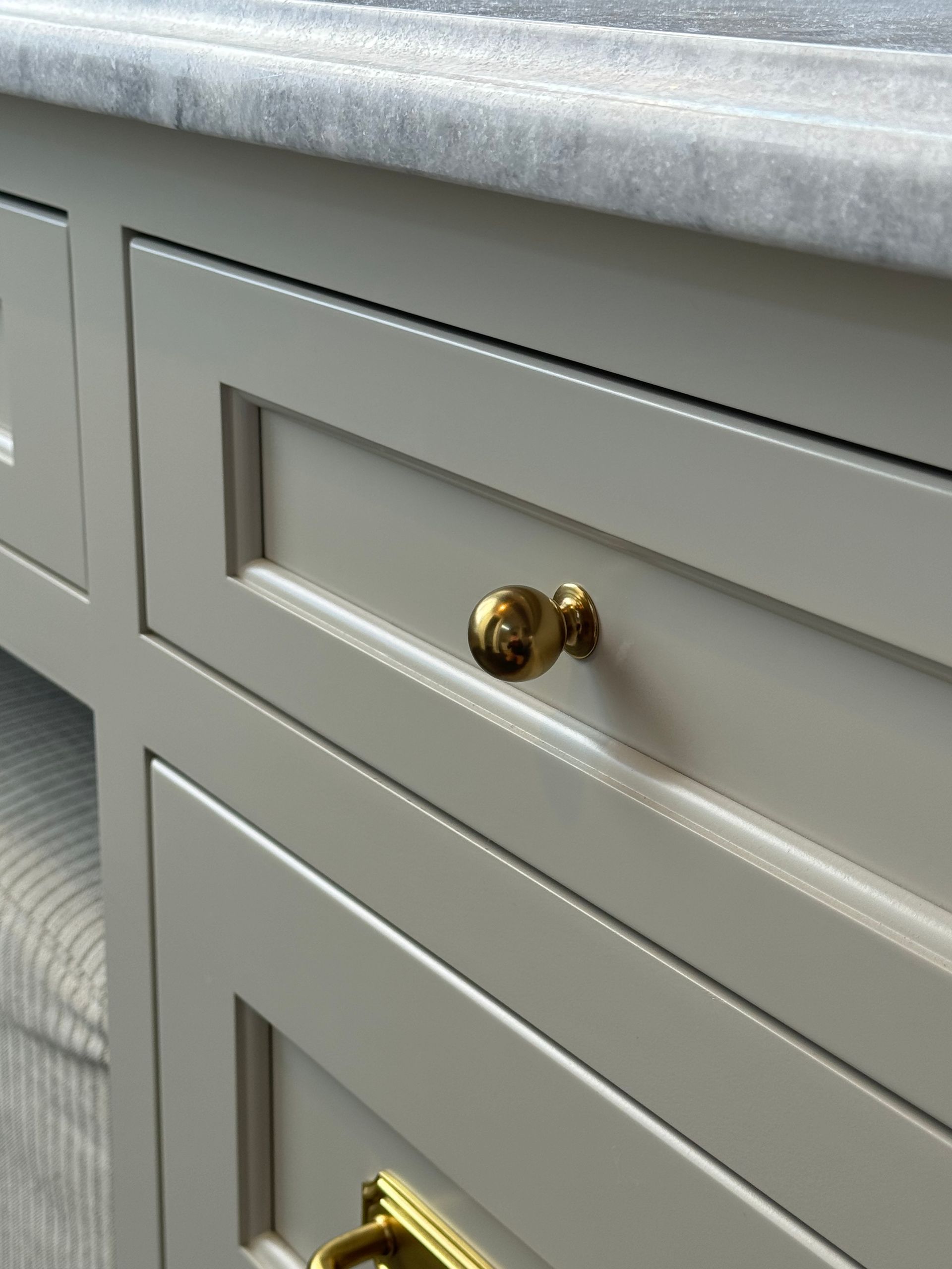 A close up of a drawer with a gold handle