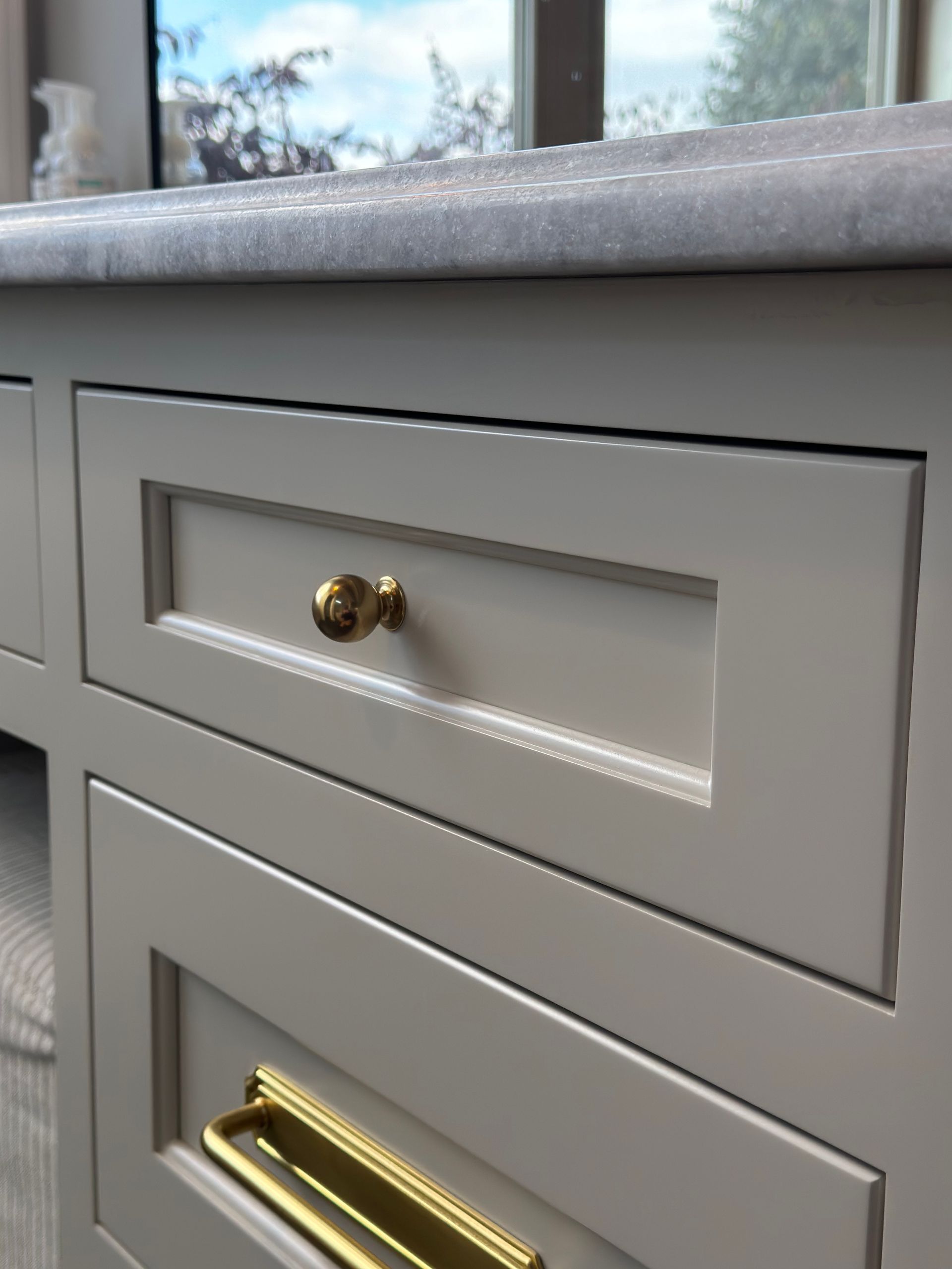 A close up of a drawer with a gold handle