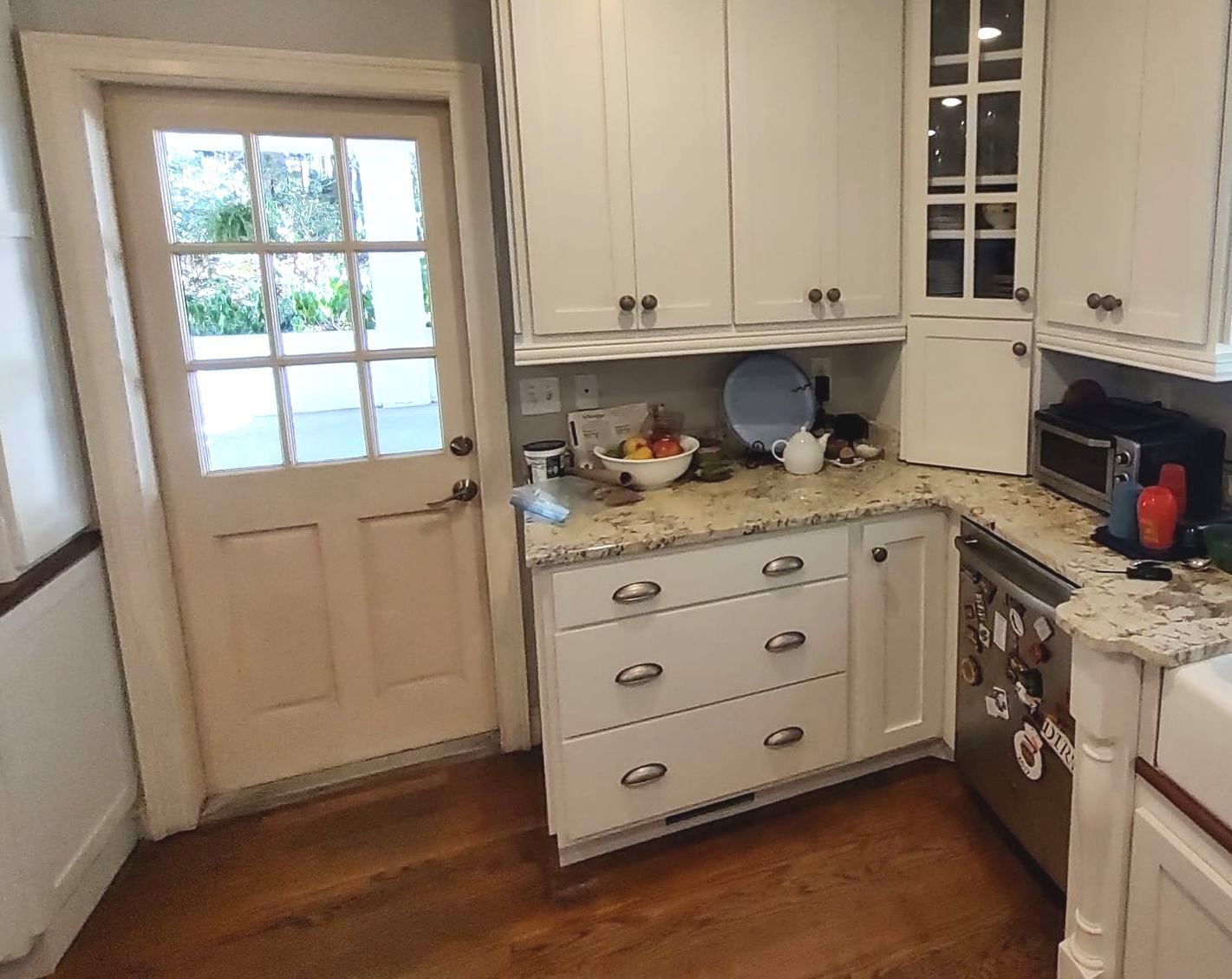 A kitchen with white cabinets and granite counter tops