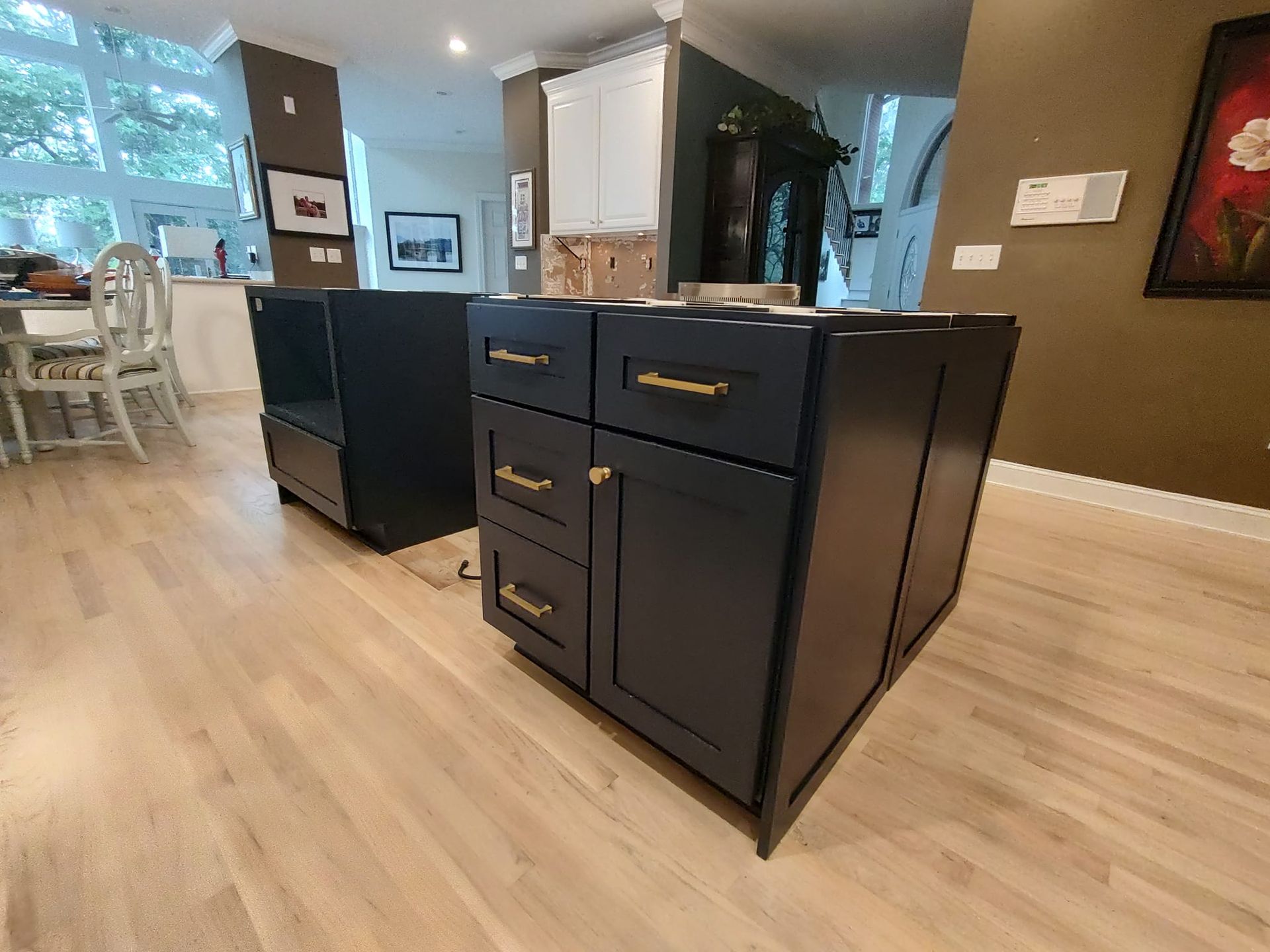 A kitchen with blue cabinets and drawers and a wooden floor.