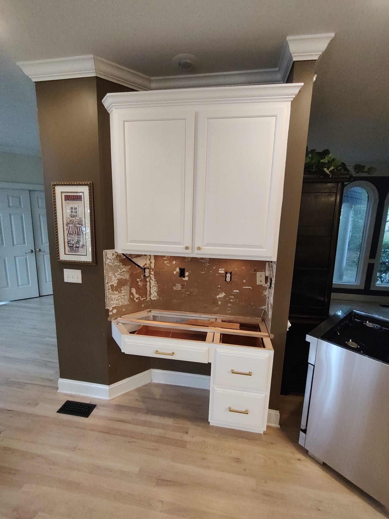 A kitchen with white cabinets and a sink in it.