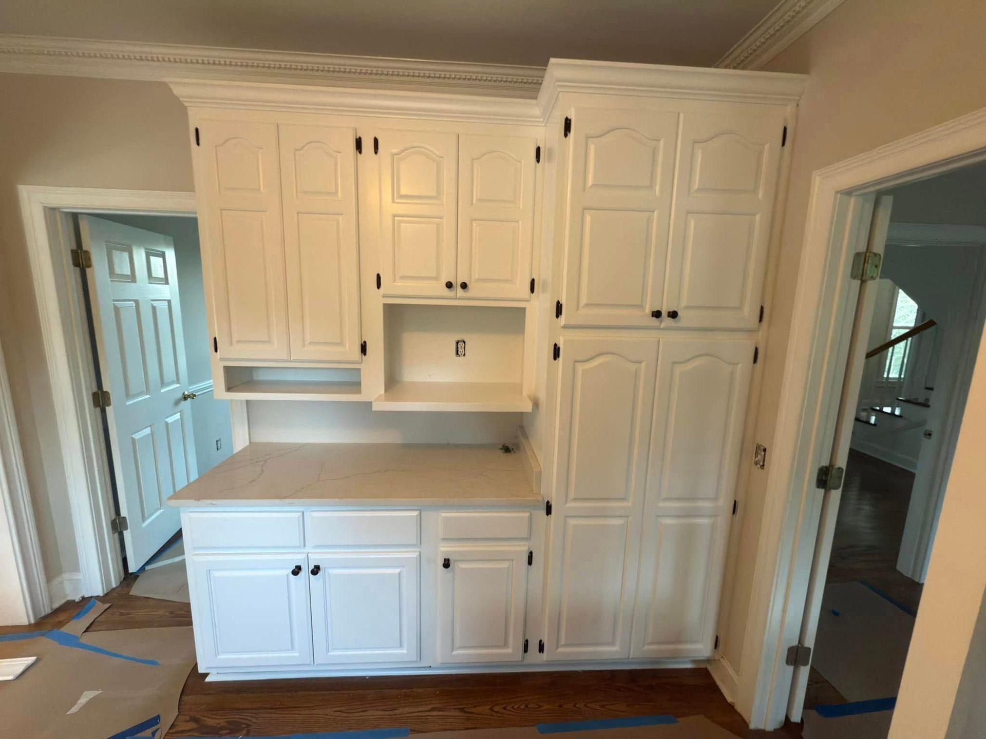 Modern kitchen with light blue cabinets, stainless steel appliances, and wood shelves.