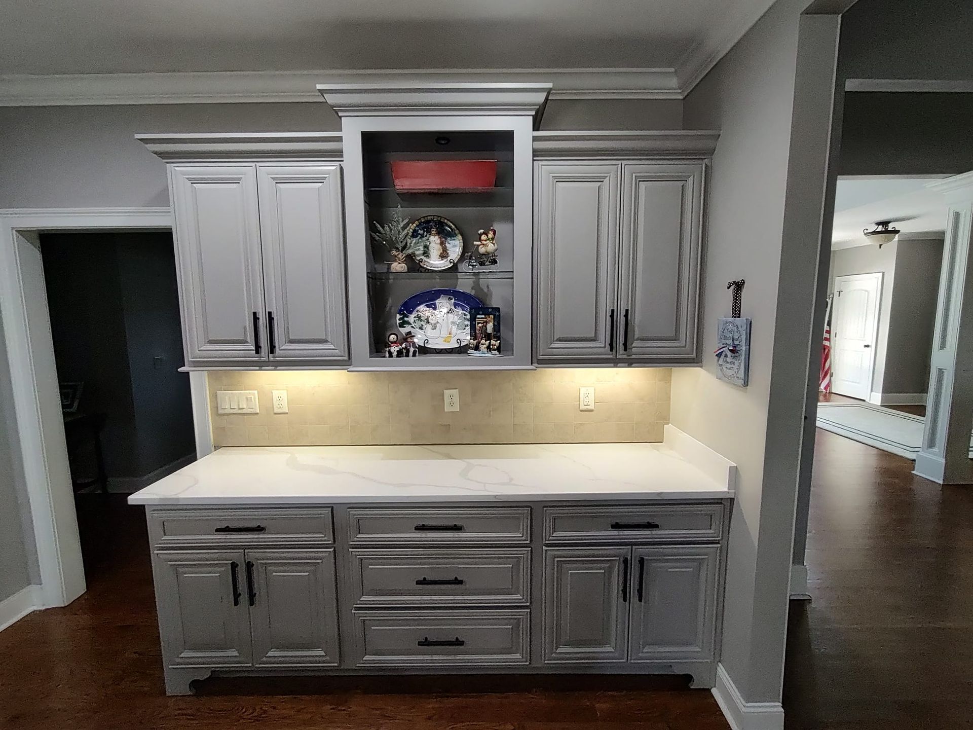 A kitchen with gray cabinets and white counter tops