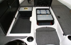 Boat storage compartments, two open with tackle boxes and storage bins. Carpeted floor with cup holders.