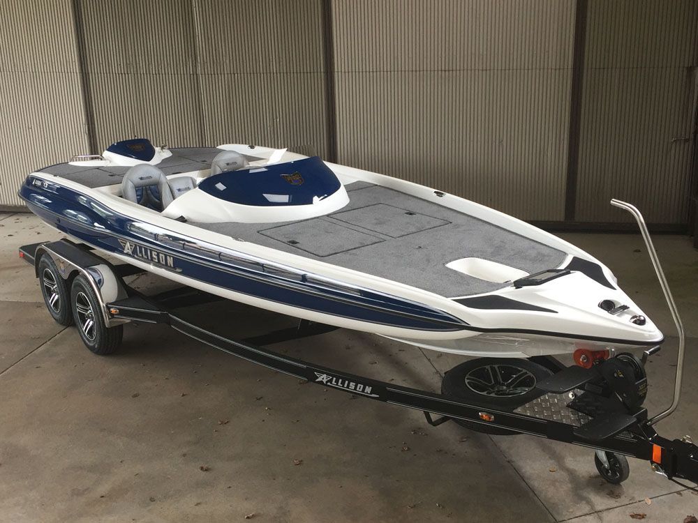 Blue and white motorboat on a trailer in a garage-like setting.