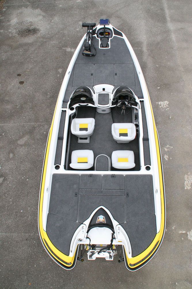 Overhead view of a bass fishing boat. White hull with black and yellow accents, two driver seats, and four passenger seats.