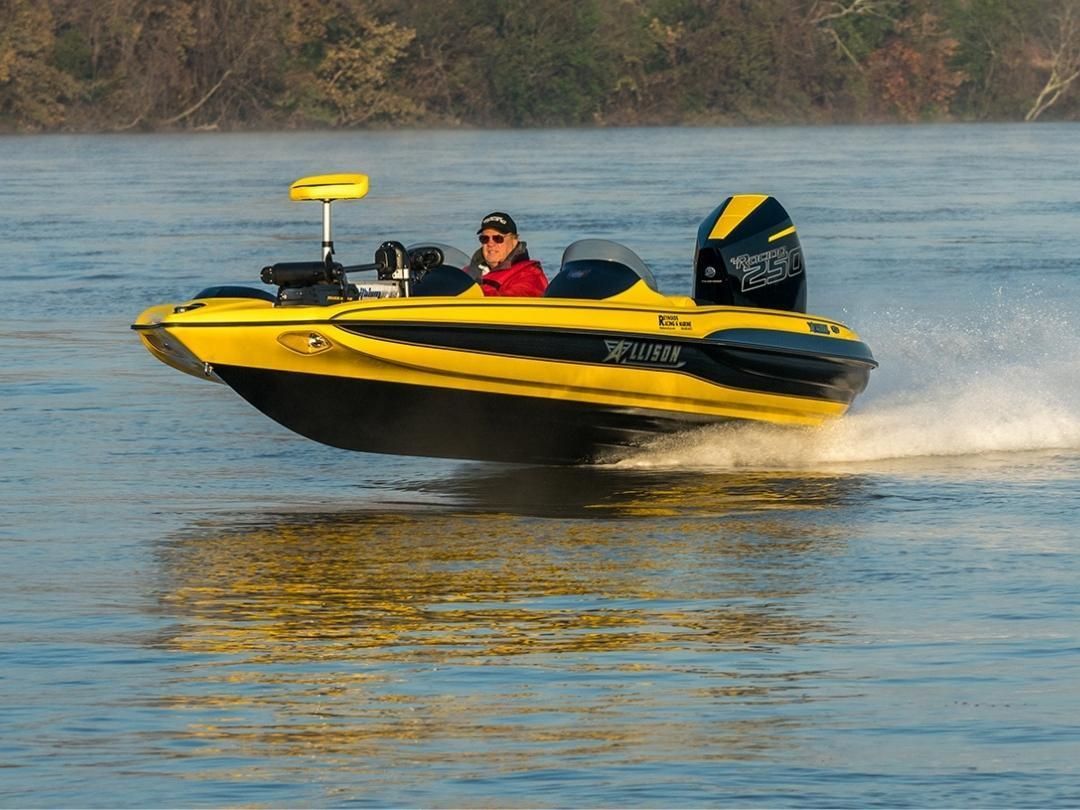 Yellow and black bass boat speeding on water, person at the helm.
