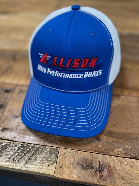 Blue and white Allison Ultra Performance Boats cap on a wooden surface.