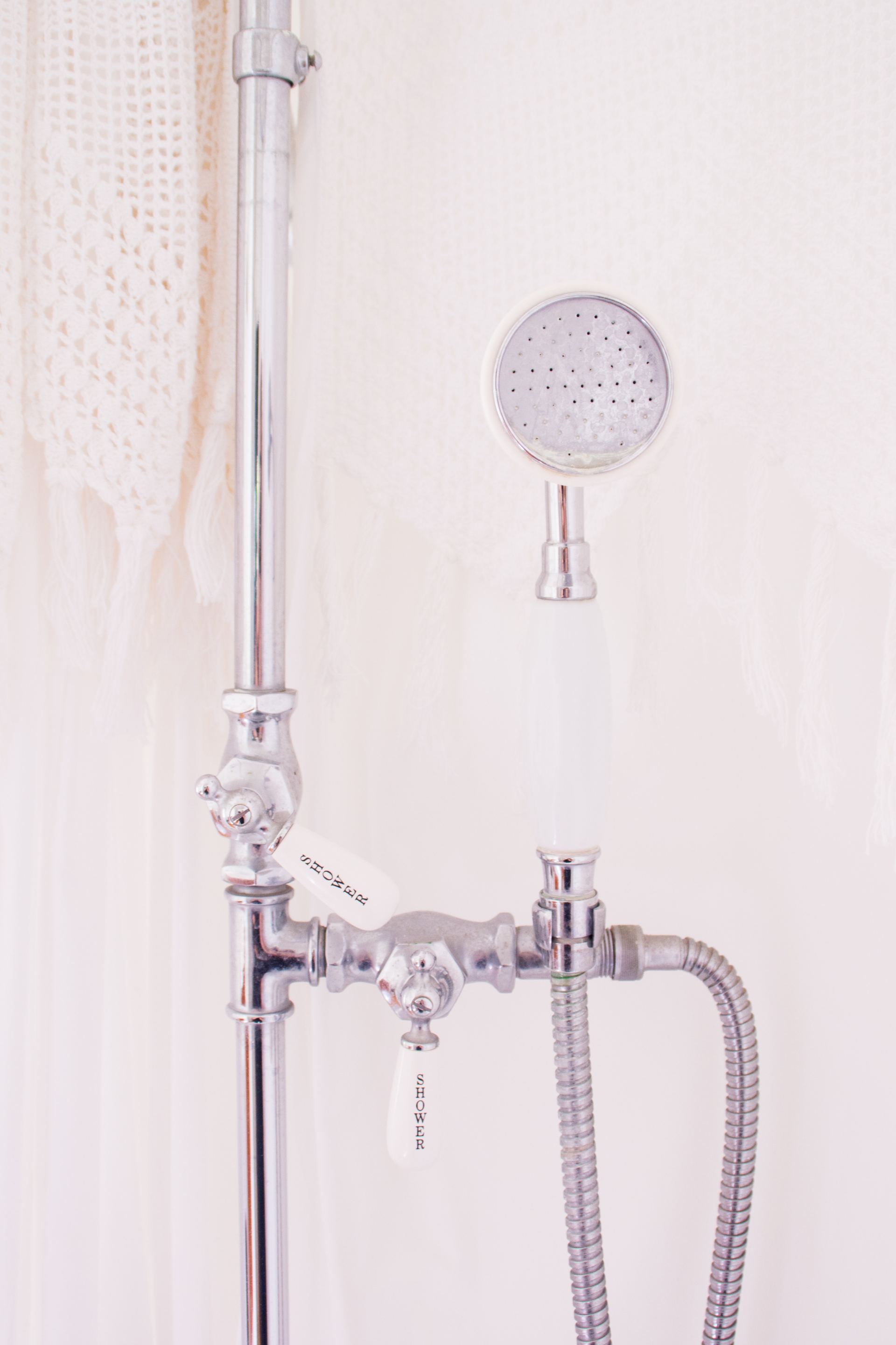 A close up of a shower head in a bathroom.