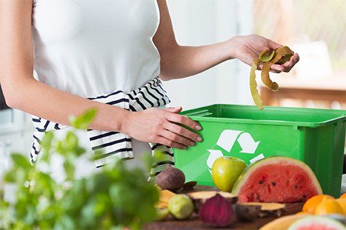 Woman Putting Food Waste In Container