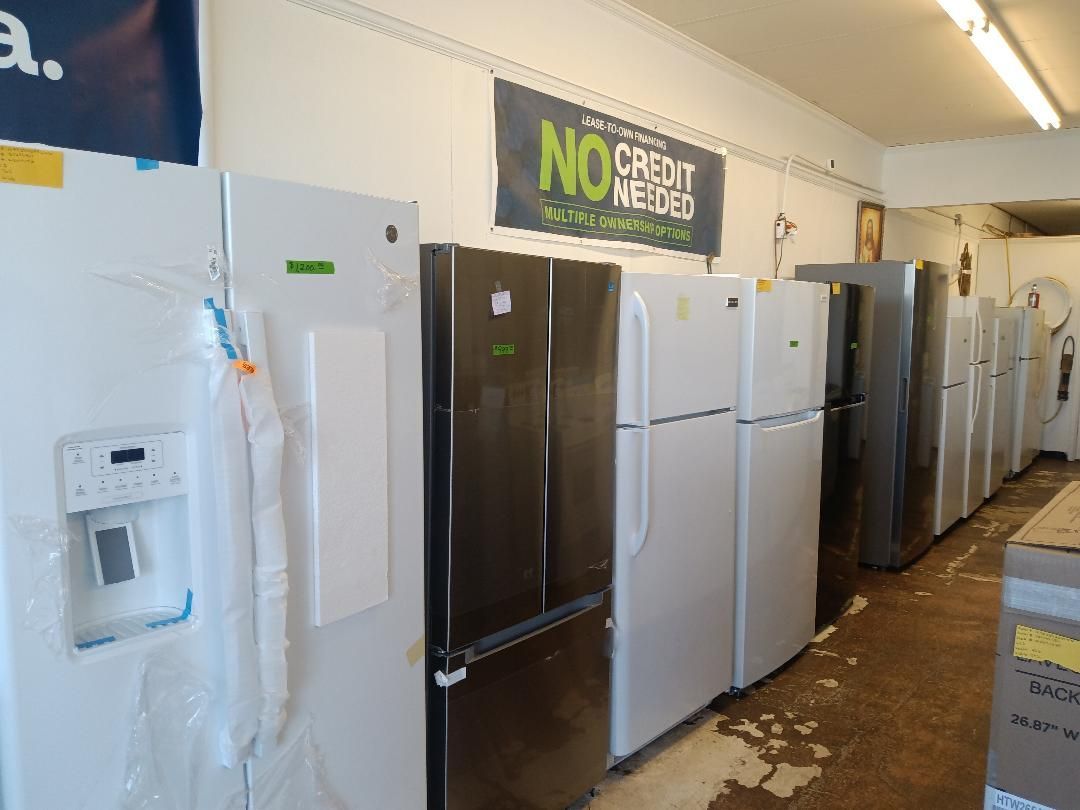 A row of refrigerators are lined up in a store.