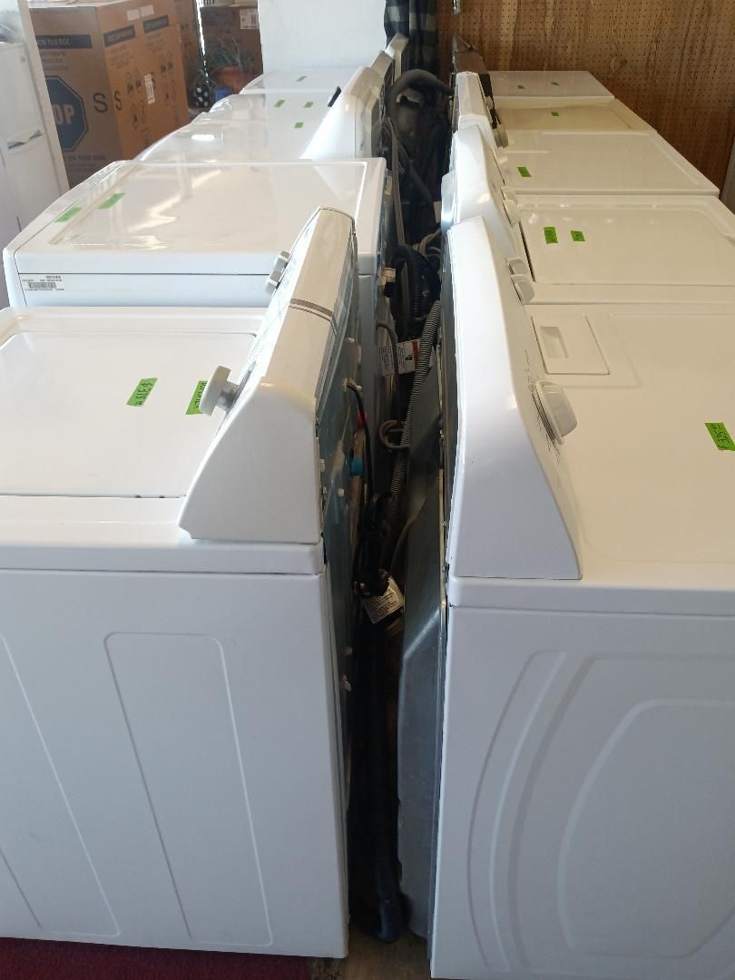 Two rows of washing machines back to back in a store.