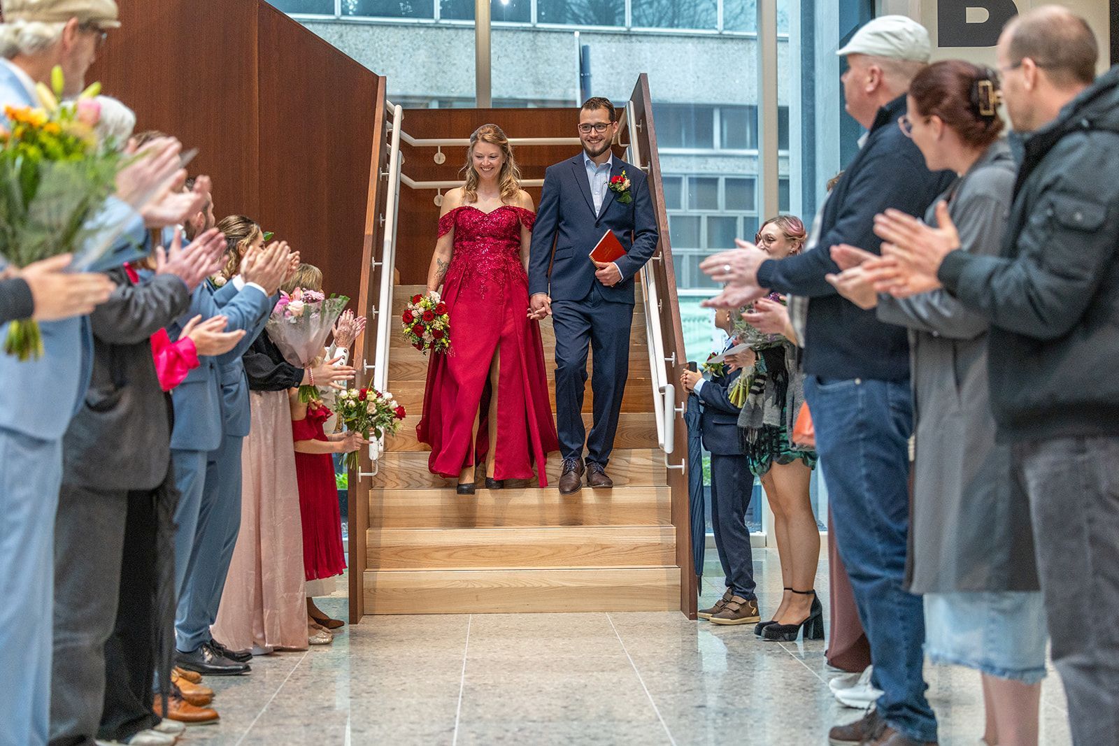 Bruid en bruidegom tijdens een huwelijksceremonie. Zij draagt ​​een witte jurk; hij draagt ​​een beige pak.