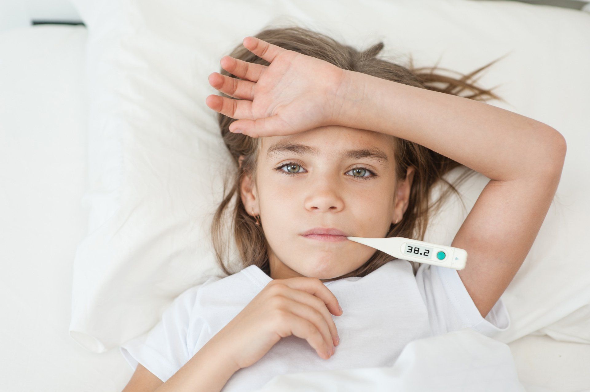 feverish little girl with digital thermometer