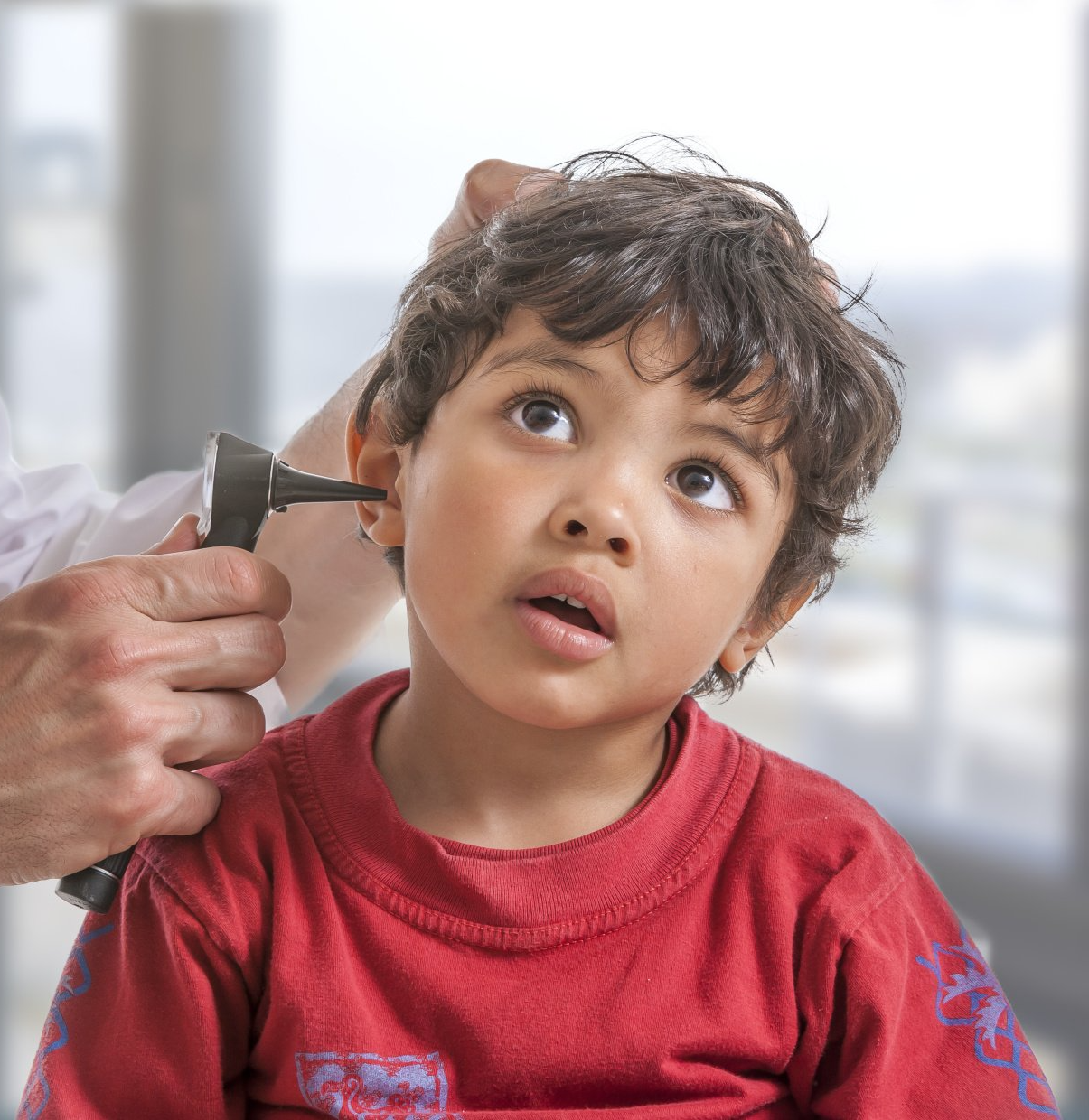 pediatrician examines little boys ear